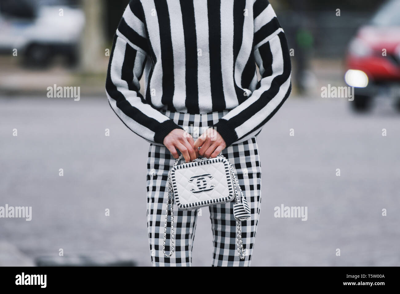 Paris, France - le 5 mars 2019 : Street style - femme vêtu de noir à  rayures blanches, pantalon à carreaux et cavalier sac Chanel, avant qu'un  pari fashion show Photo Stock - Alamy