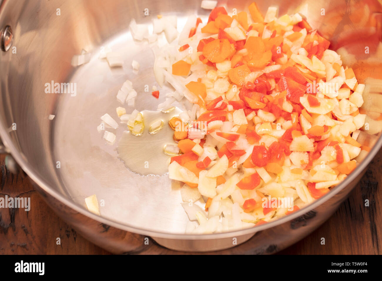 Carottes tranchées et haché, l'ail et l'oignon dans une casserole avec de l'huile prêt à être d'une sauce à spaghetti sautés Banque D'Images