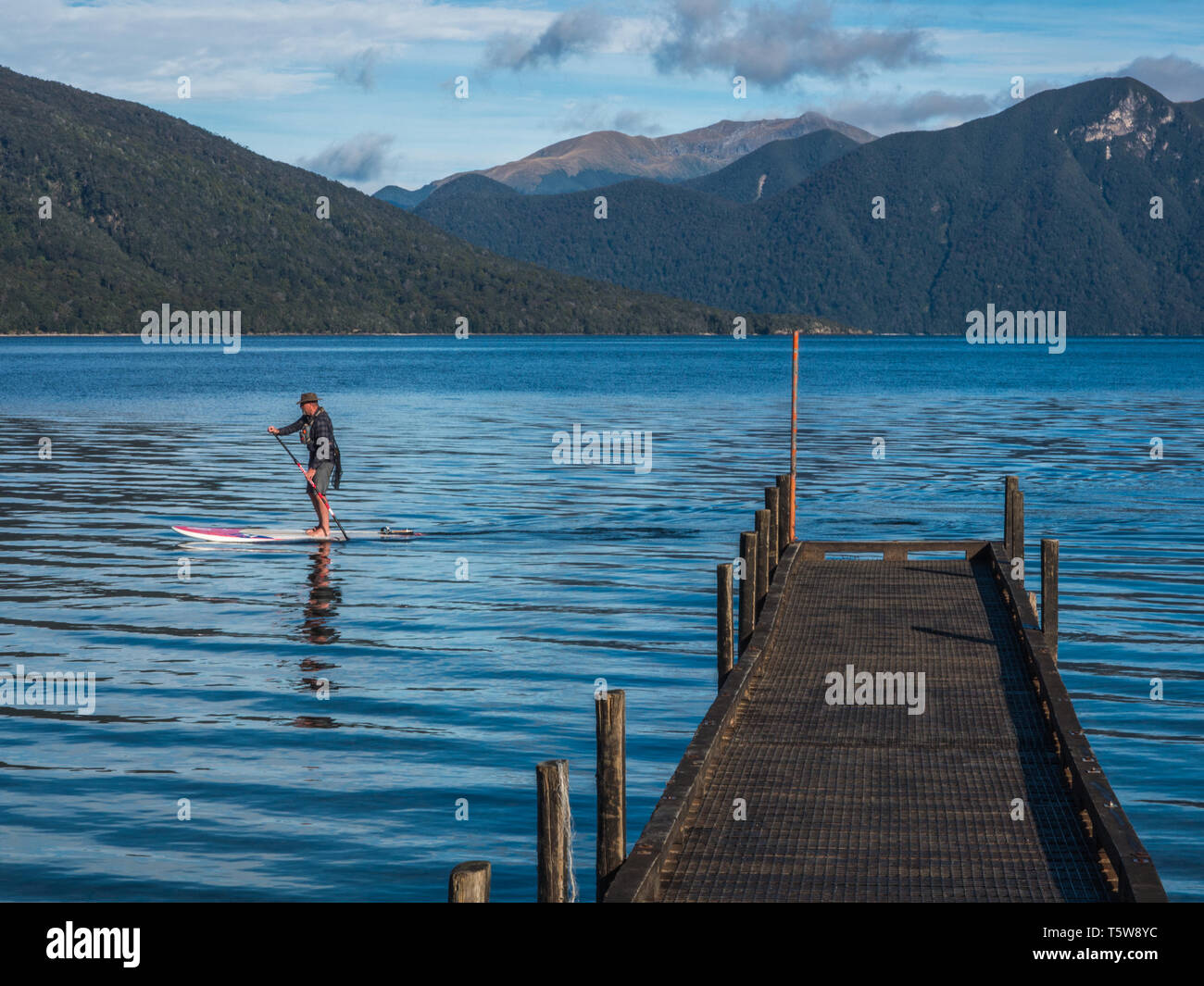 L'homme sur paddleboard, lac Hauroko, Fiordland National Park, Southland, Nouvelle-Zélande Banque D'Images