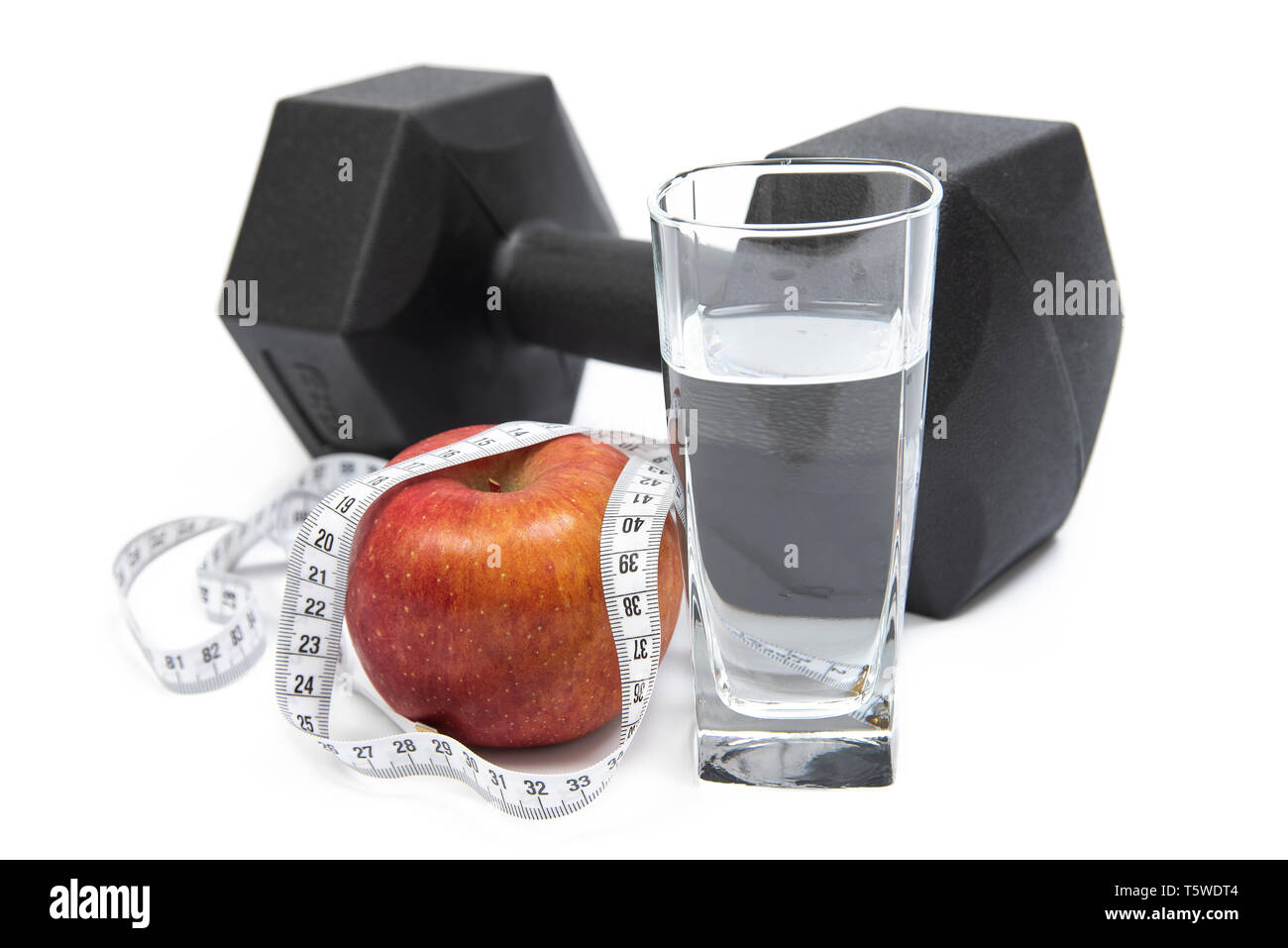 Haltères en noir, tasse, ruban de mesure et d'Apple sur un fond blanc. Banque D'Images
