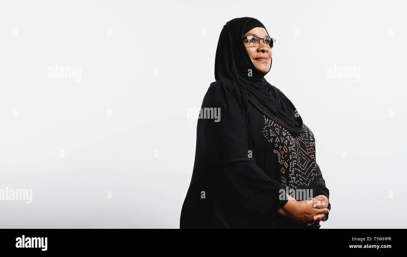 Les femme en hijab isolé sur fond blanc. Smiling woman arabe dans les lunettes et d'un hijab noir à la voiture. Banque D'Images
