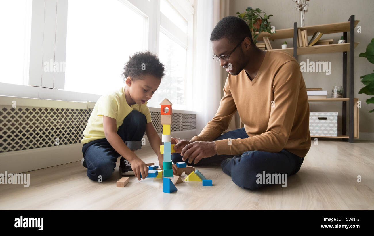 Père et fils assis sur marbre jouer avec des blocs de jouets Banque D'Images