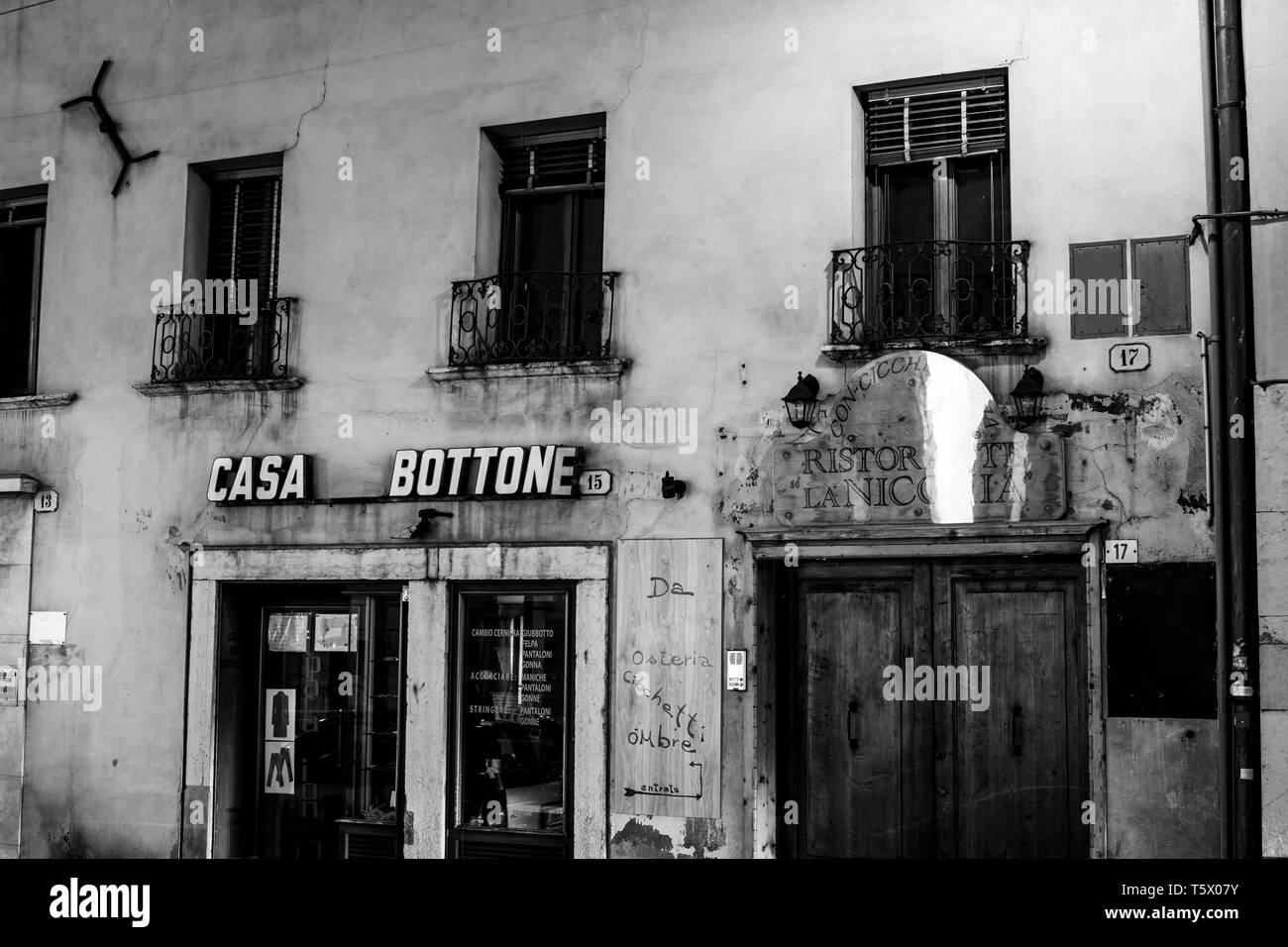 Ancienne vue de monochrome d'un ancien bâtiment avec un petit magasin sur un square at night Banque D'Images