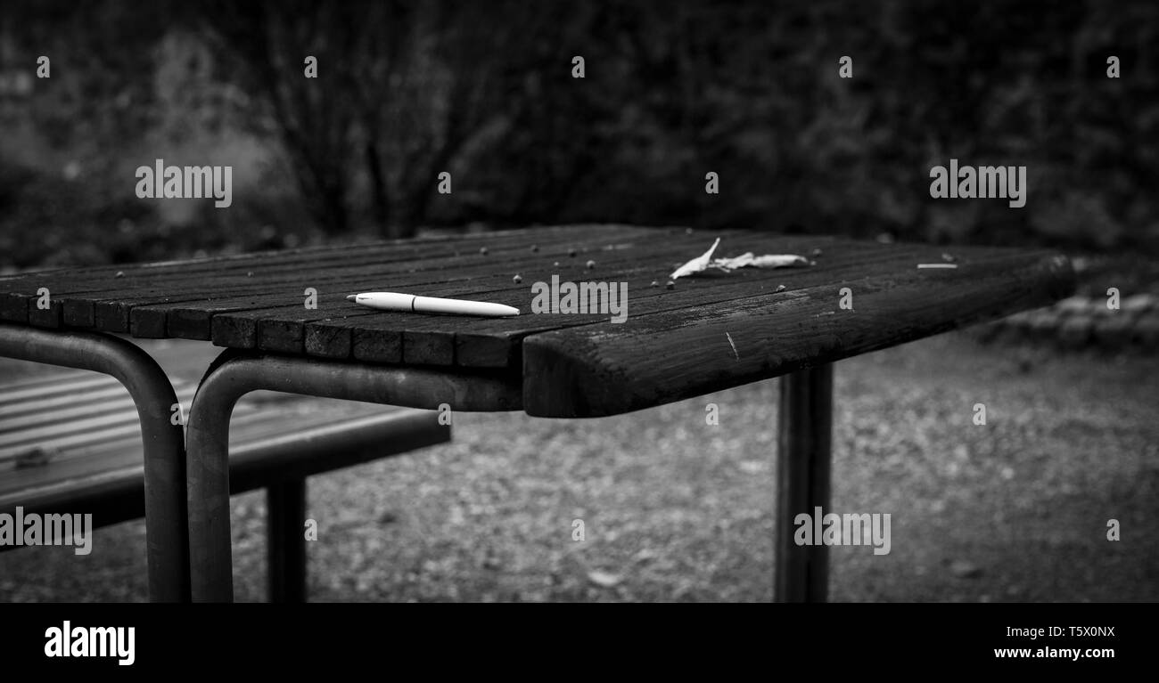 Une table avec banc dans le parc urbain avec un crayon blanc sur elle à l'automne Banque D'Images