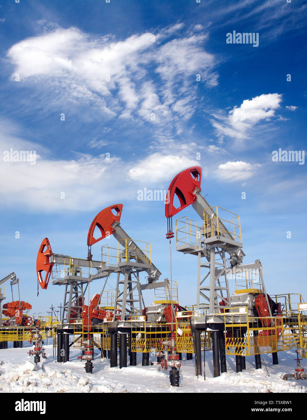 Industrie du pétrole et du gaz. De travail sur un champ de pétrole. Les nuages blancs et ciel bleu au-dessus du champ d'huile Banque D'Images