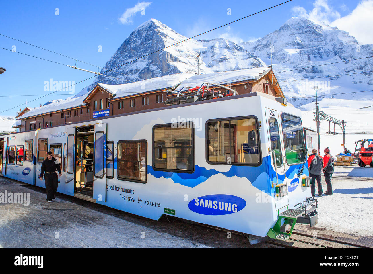 Samsung train à la Kleine Scheidegg railway station en hiver, avec l'Eiger et du Mönch montagnes derrière. Oberland Bernois, Suisse (Suisse) Banque D'Images