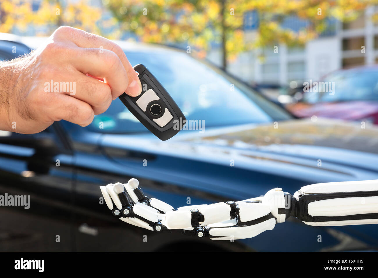 Close-up de la main d'un homme clé de voiture donnant au robot Banque D'Images