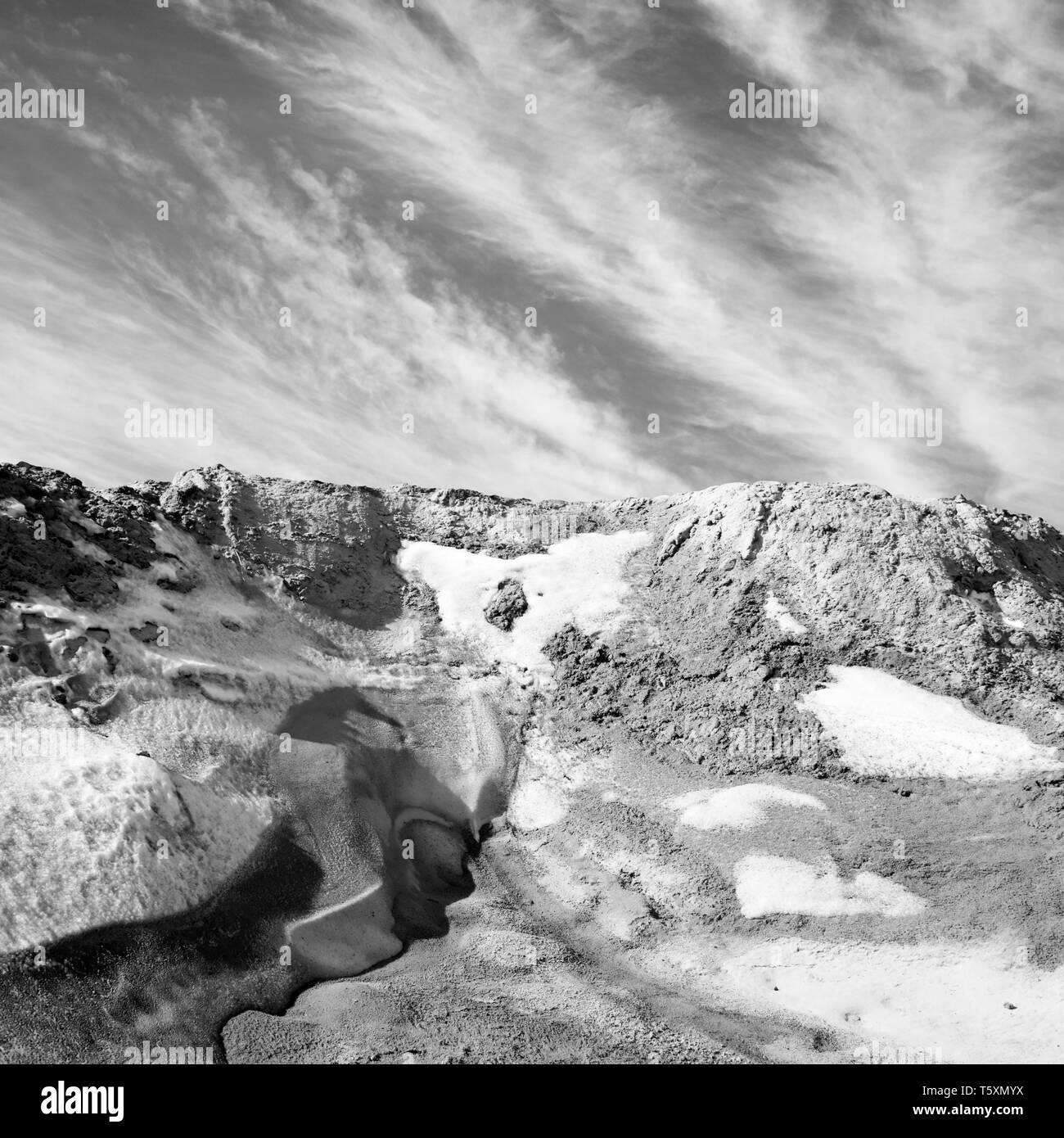 Falaise de neige dans les montagnes de l'Oural. Temps de printemps. Photo en noir et blanc Banque D'Images