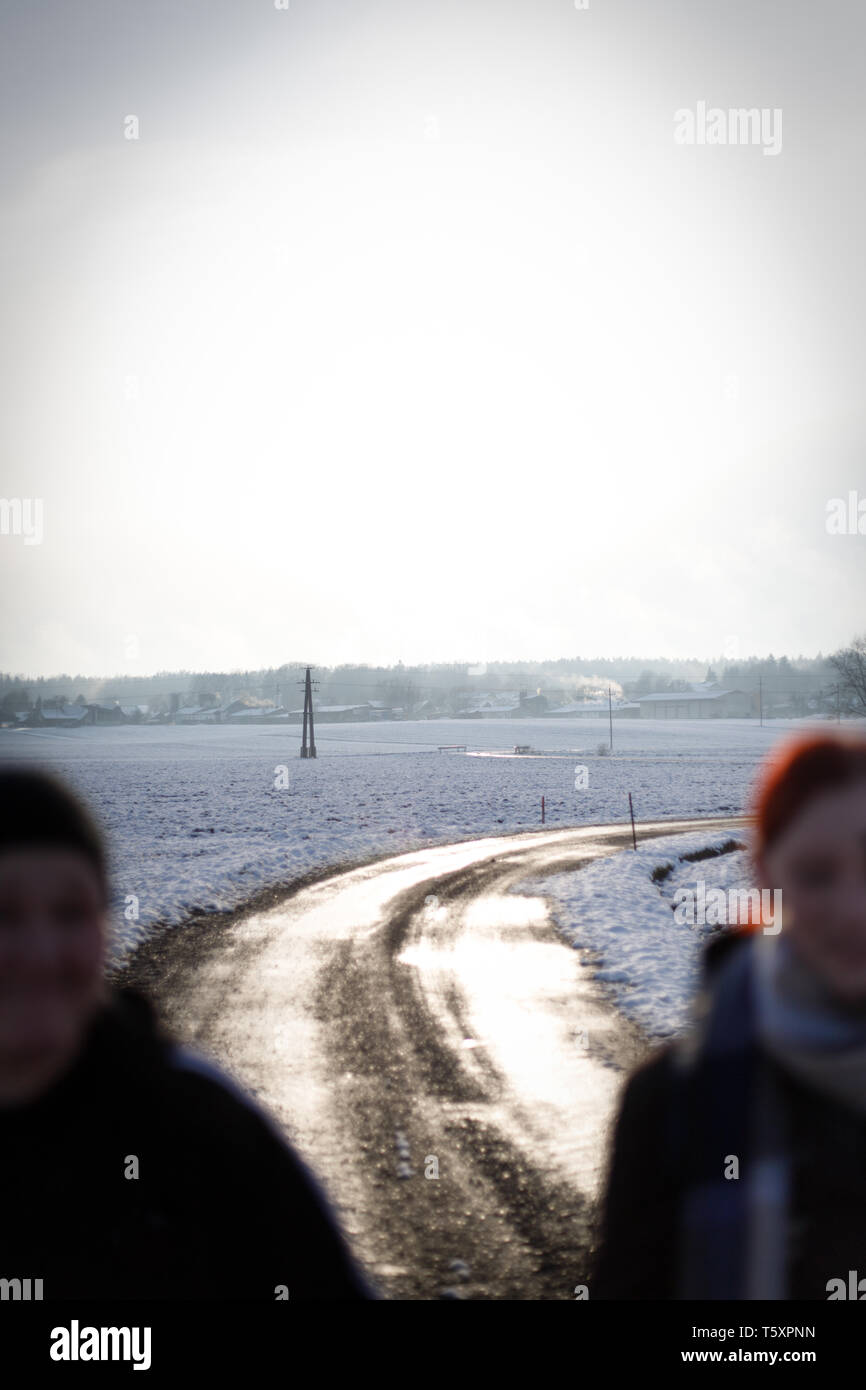 Deux jeunes Pretty woman walking et rire sur un chemin rural sur un dimanche d'hiver neigeux ensoleillé Banque D'Images
