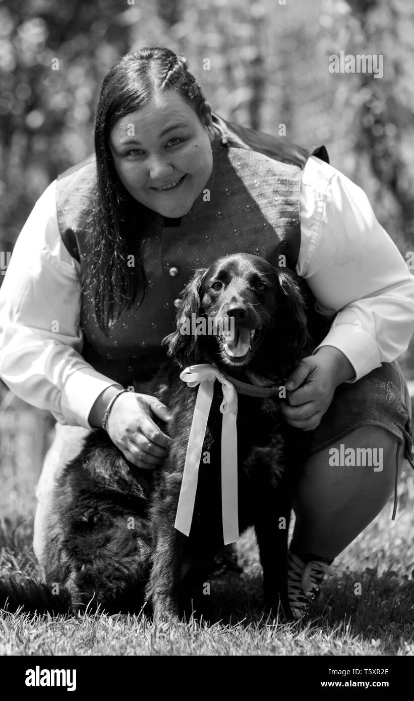 Jeune belle mariée dans un lederhose avec sa meilleure amie son chien au mariage Banque D'Images