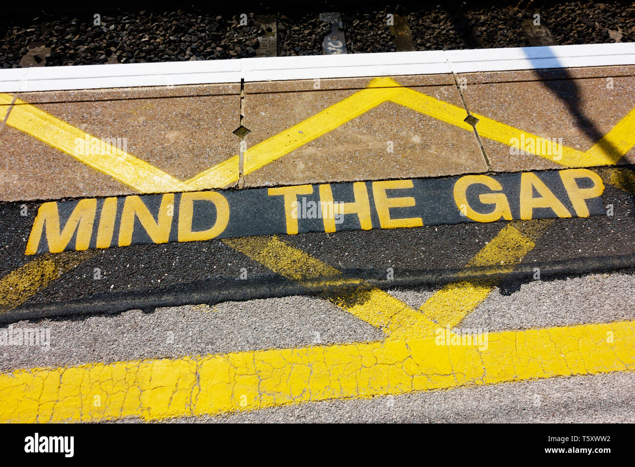 'Mind l'écart' panneau d'avertissement sur le bord de la plate-forme ferroviaire. Banque D'Images