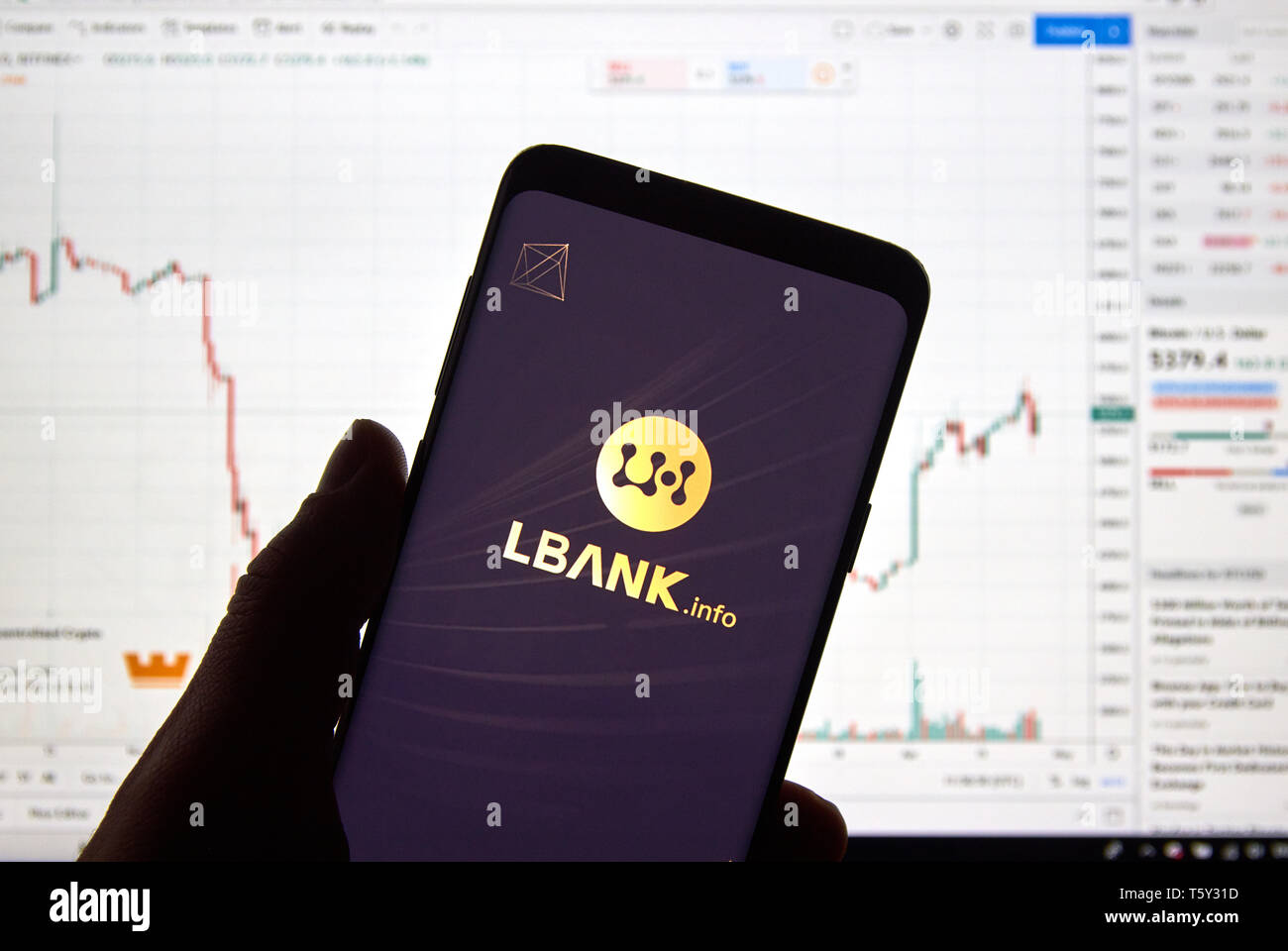 Montréal, Canada - le 26 avril 2019 : Lbank cryptocurrency logo change et l'application sur Android Samsung Galaxy S9 Plus dans la main sur un ordinateur portable Banque D'Images