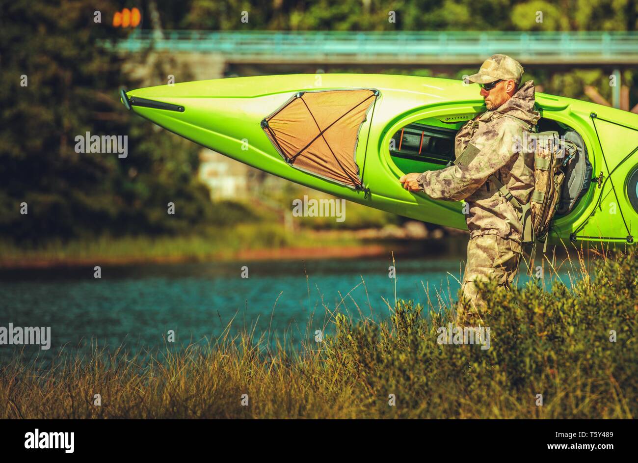 Les hommes de race blanche pour préparer un voyage en kayak o n la pittoresque rivière. Thème Loisirs d'été. Banque D'Images