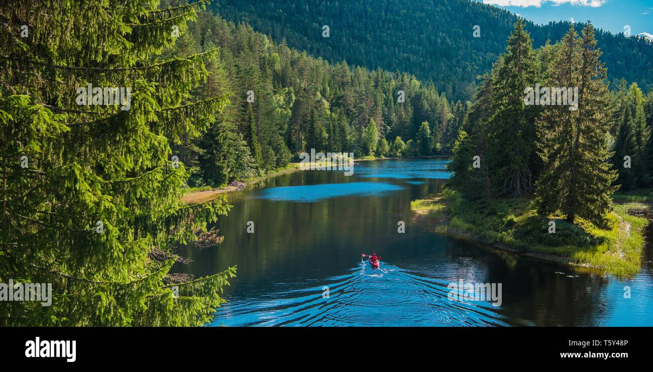 Scenic River Kayak Voyage. Les hommes de race blanche dans un Kayak entouré par la nature norvégienne d'été. Banque D'Images