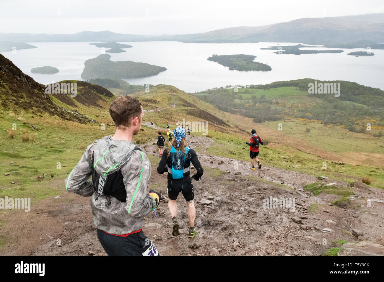 Conic Hill, Loch Lomond, Ecosse, Royaume-Uni - 27 avril 2019 - Royaume-Uni - très fortes averses partiellement masquer la vue sur le Loch Lomond pour ultra marathoniens ordre décroissant Conic Hill dans les premières étapes de la course 53 km highland fling. Le difficile marathon ultra trail race suit le chemin de la West Highland Way à travers le Loch Lomond et les Trossachs National Park entre Milngavie et Tyndrum. Credit : Kay Roxby/Alamy Live News Banque D'Images