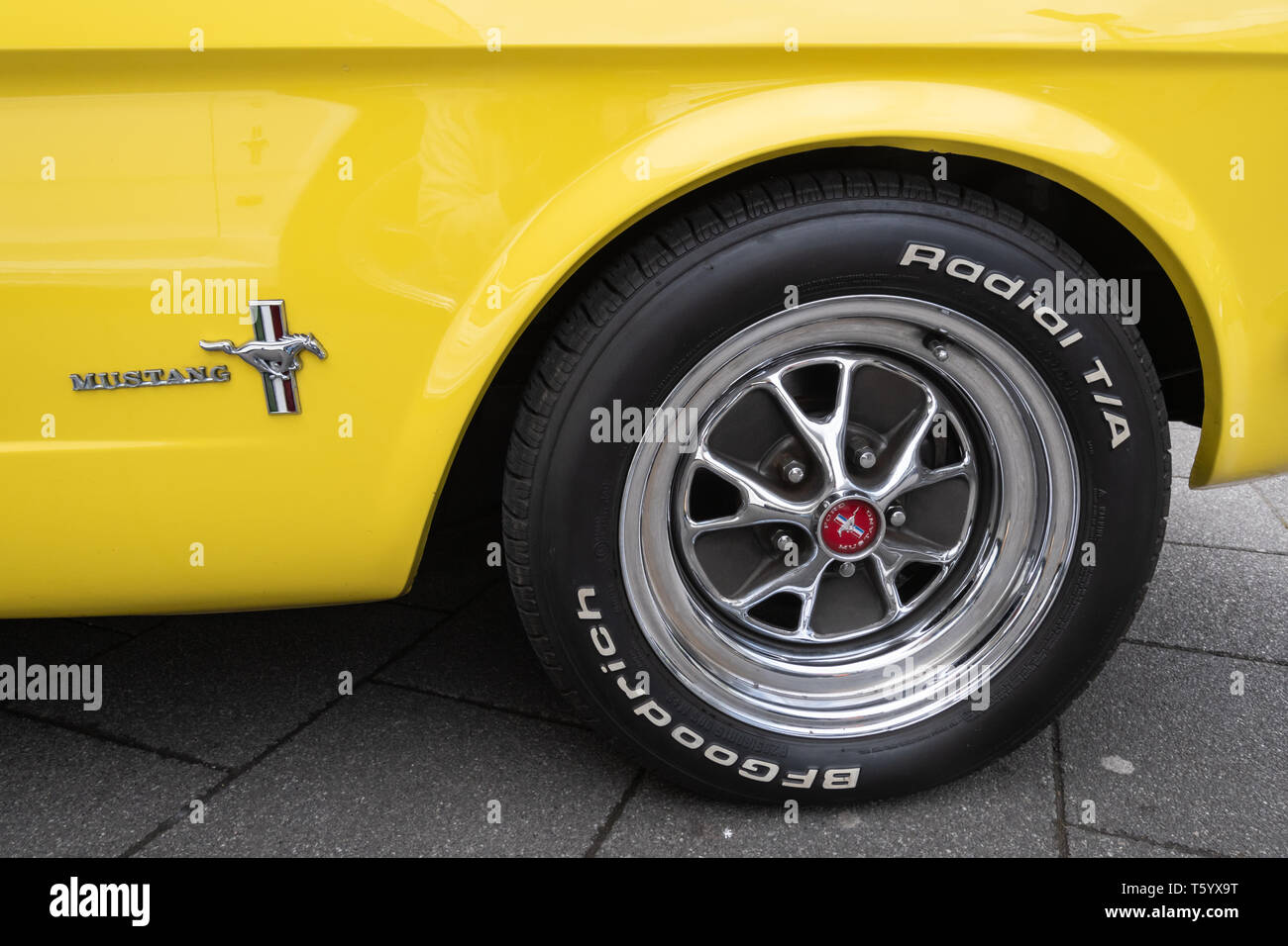 La roue et d'un insigne sur une Ford Mustang 1965 jaune 4700cc voiture dans un classic motor vehicle show au Royaume-Uni. American automobile. Banque D'Images