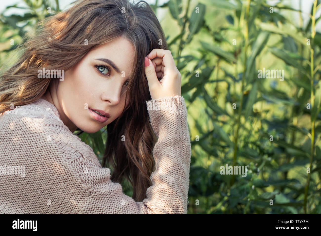 La beauté naturelle. Belle femme face close up. Joli modèle féminin sur fond d'herbe verte biologique Banque D'Images