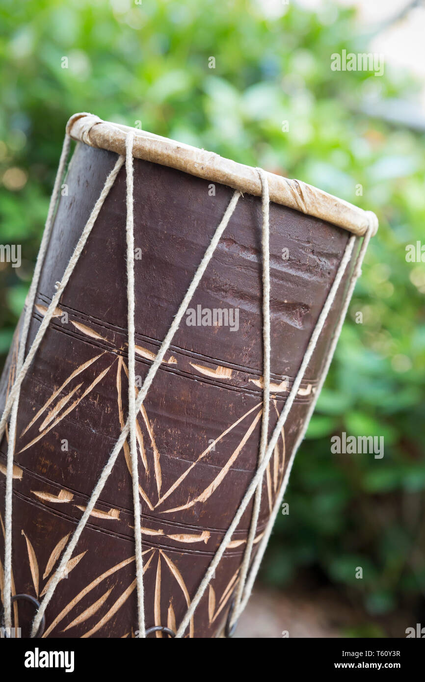 Close-up vue latérale d'un simple traditionnelle africaine, tambour à main (musical instrument à percussion) dans l'air extérieur, cadre naturel. Banque D'Images
