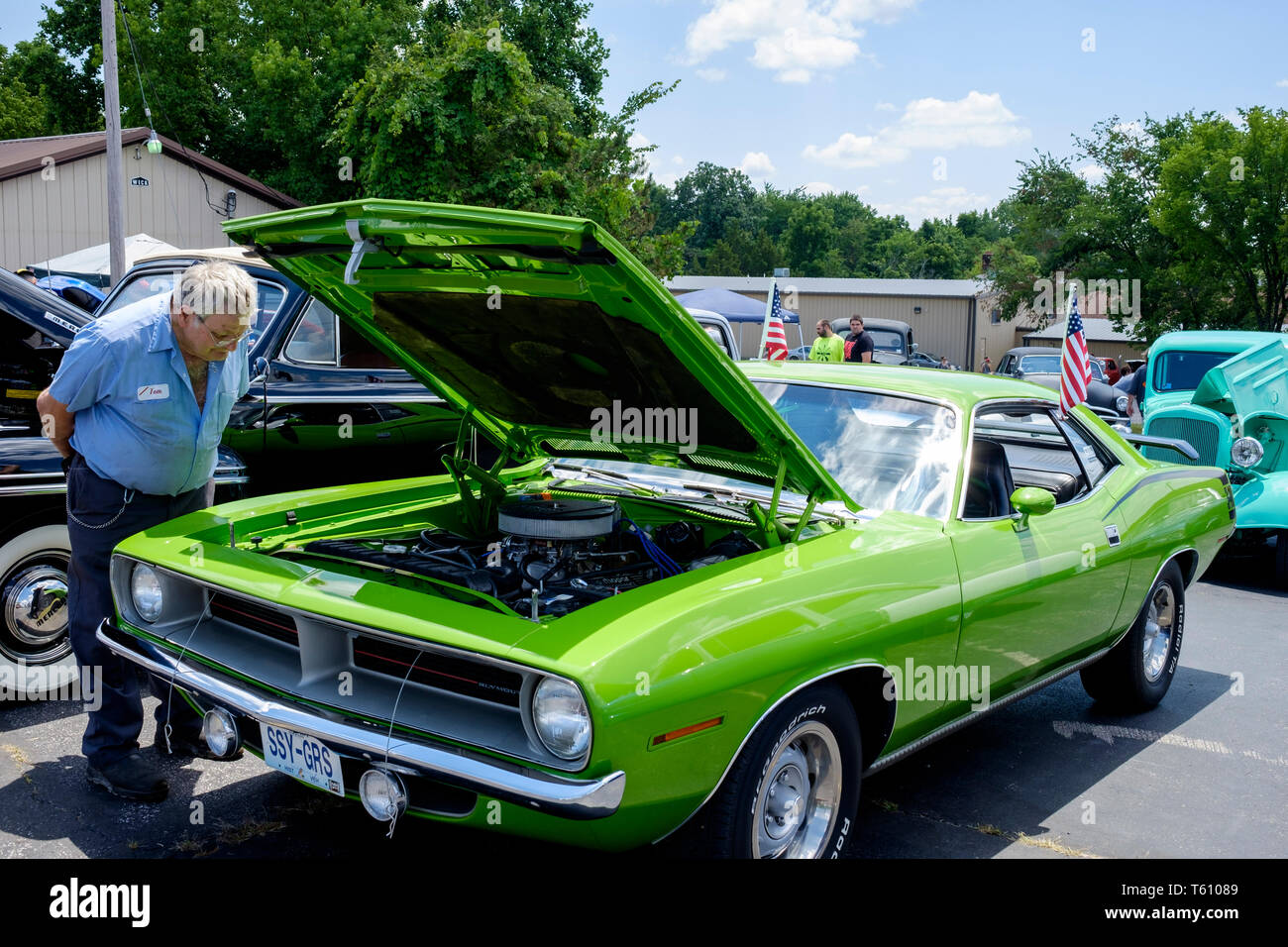 Homme de race blanche visiteur de près le moteur sous le capot d'une Chevrolet Impala voiture classique sur un open-air car show dans le Missouri, USA Banque D'Images