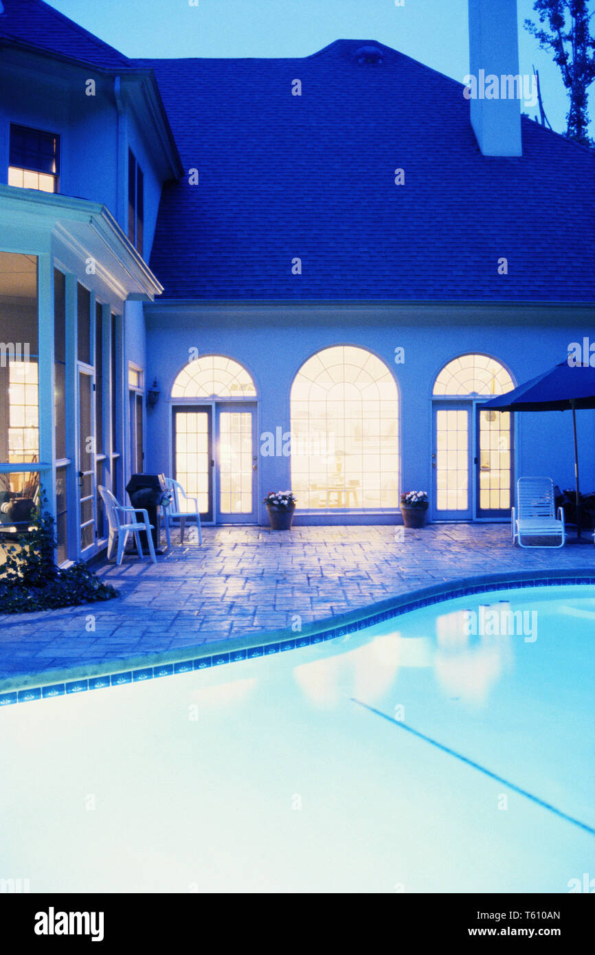 Maison de banlieue huppée de nuit avec piscine éclairée et pont, USA Banque D'Images