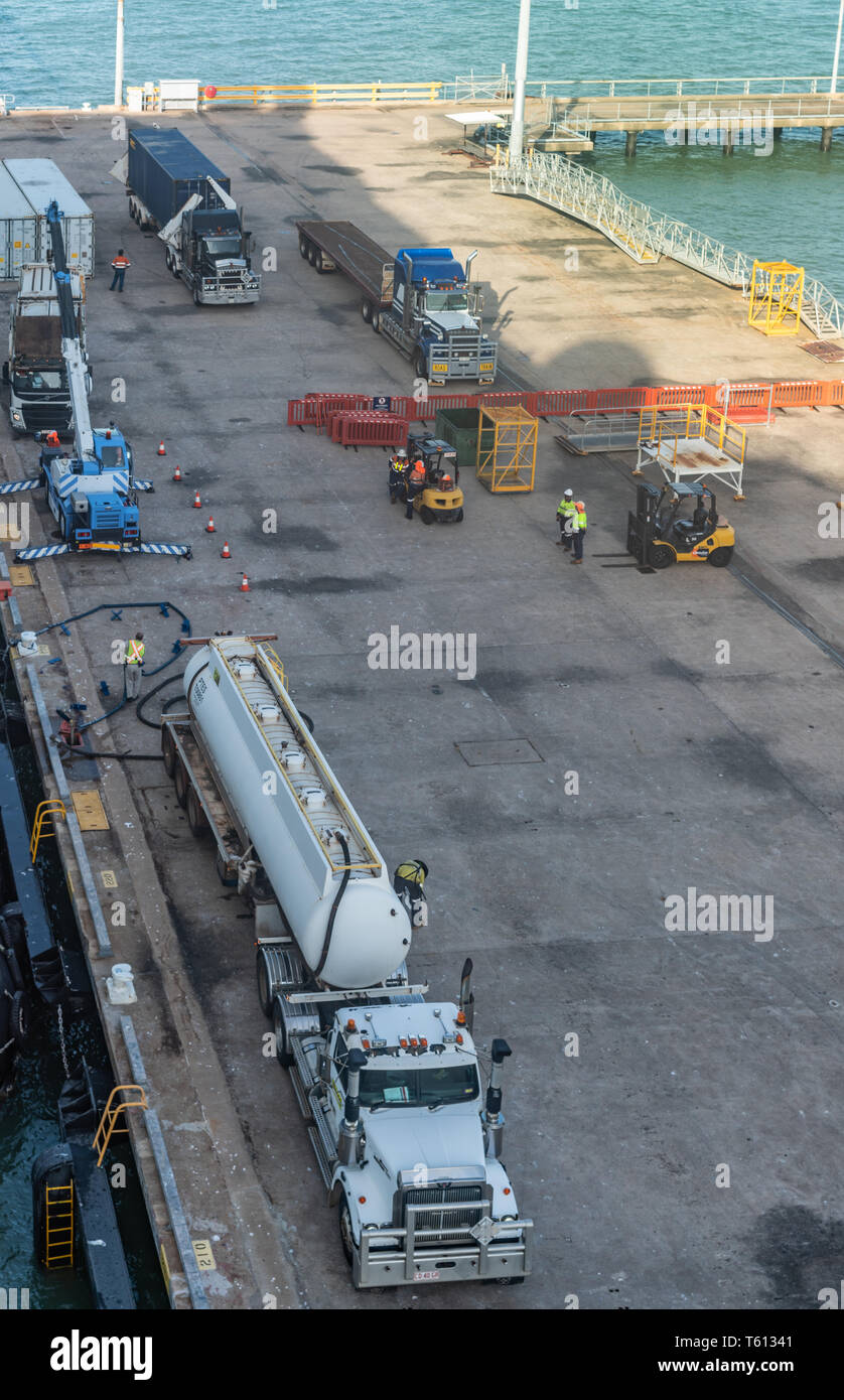 Darwin Australie - 22 Février 2019 : camion citerne gris navire de ravitaillement est stationnée le long du navire. D'autres camions et les gens sur le quai. Banque D'Images