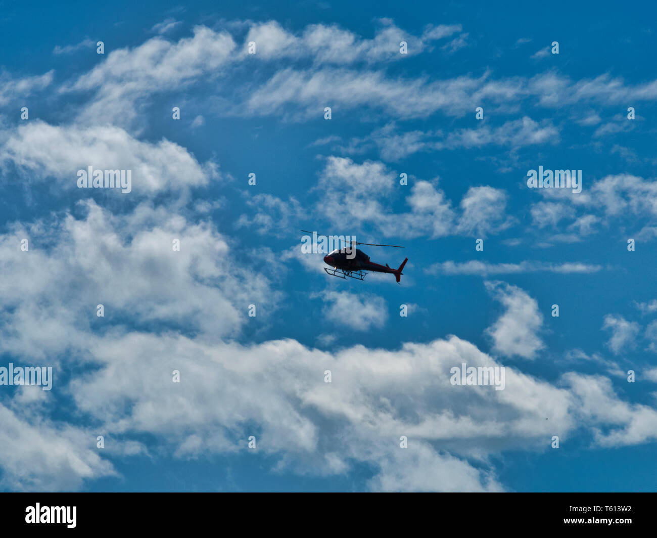 Avion hélicoptère volant dans le ciel bleu avec des nuages à l'extérieur. Banque D'Images