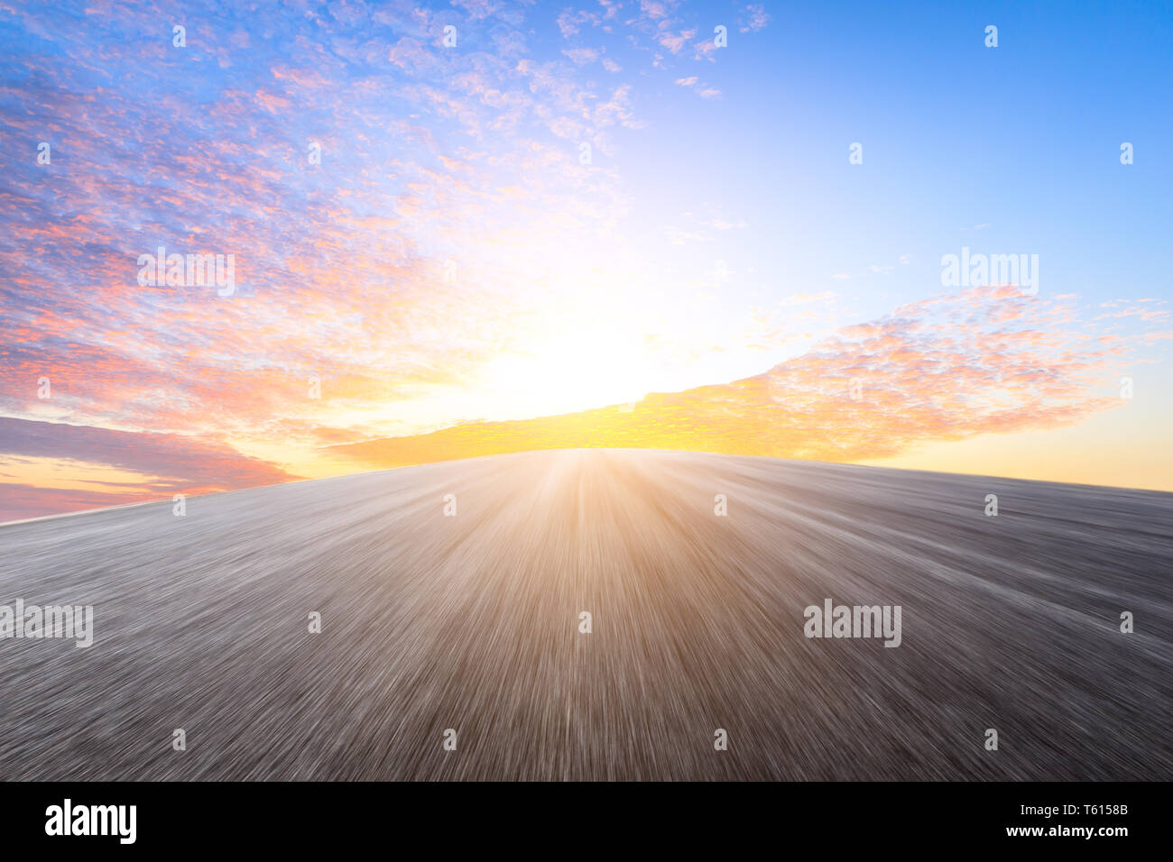 Motion blurred route asphaltée de soleil nuages ciel et terre Banque D'Images