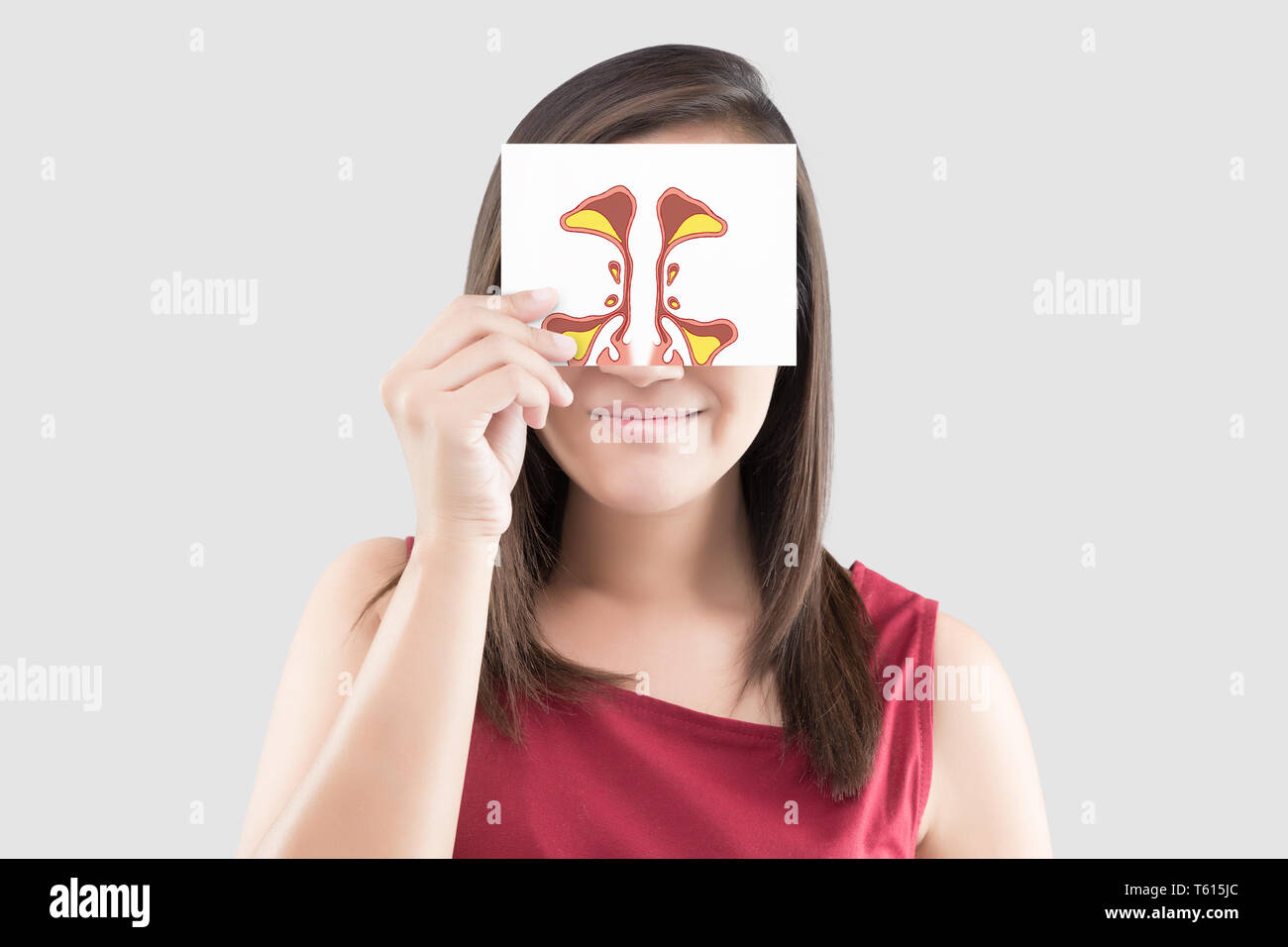 Smiling woman hold photo sinus sur du papier blanc sur le fond gris, Portrait de femme belle dans la chemise rouge papier tenant dans sa main contre Banque D'Images