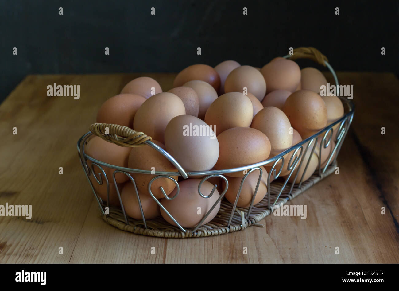 Oeufs dans un panier sur la table rustique en bois - d'œufs dans le plateau métallique décorative Banque D'Images