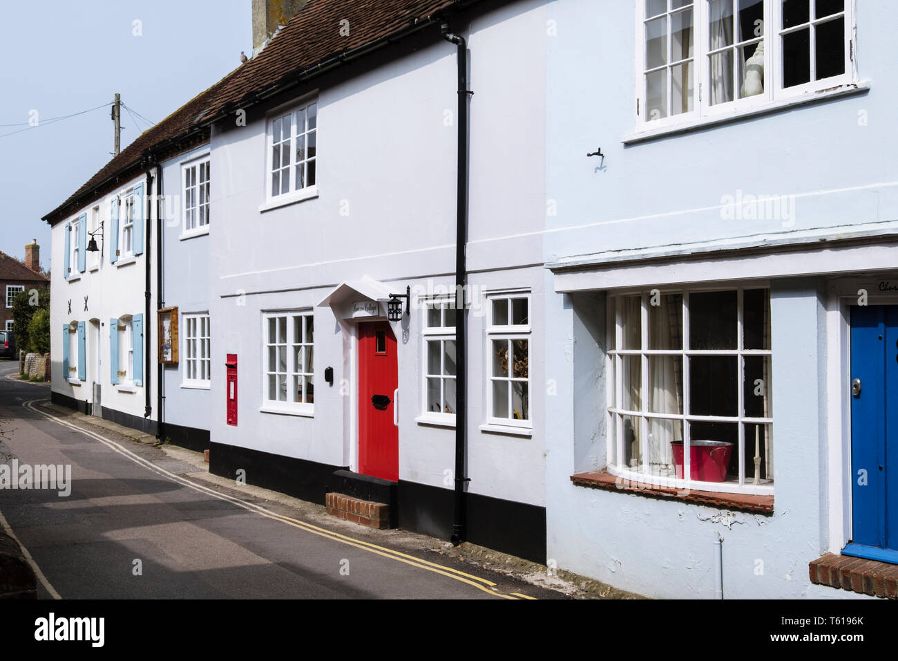 Maisons anciennes aux défenses contre les inondations à l'avant porte sur la rue étroite près de front de mer. Bosham, Chichester, West Sussex, Angleterre, Royaume-Uni, Angleterre Banque D'Images