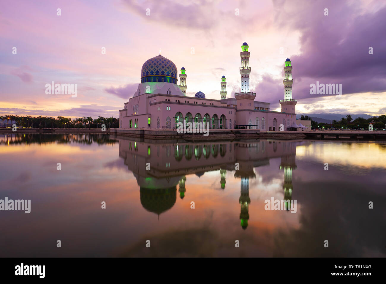 La mosquée de la ville de Kota Kinabalu reflète dans lagoon pendant le lever du soleil. Banque D'Images
