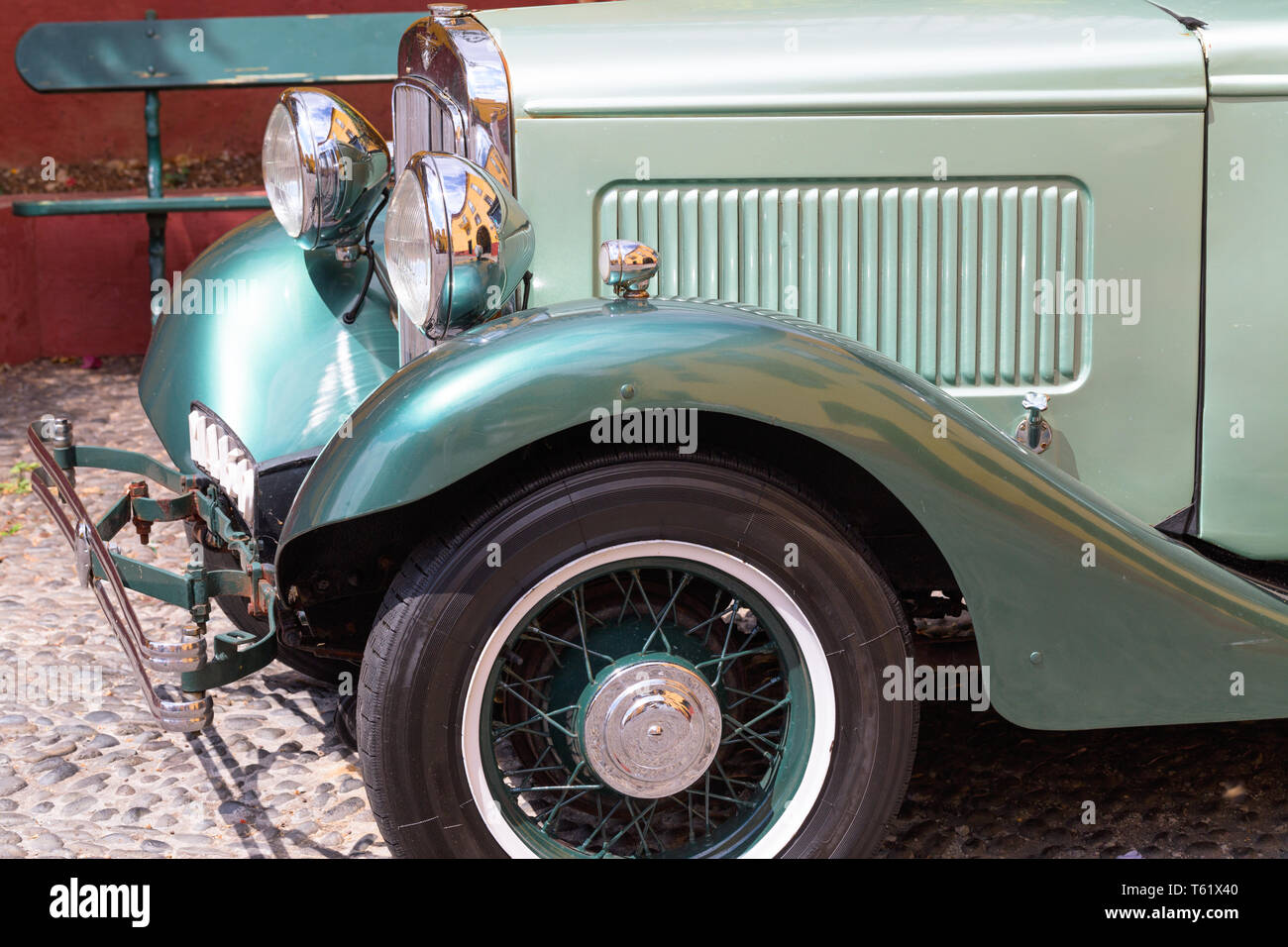 Roue, l'aile et le phare d'une 1932 vintage voiture garée à Fortaleza de Sao Tiago à Funchal. Green car, nickelé brillant, projecteur vieux cobblestone Banque D'Images