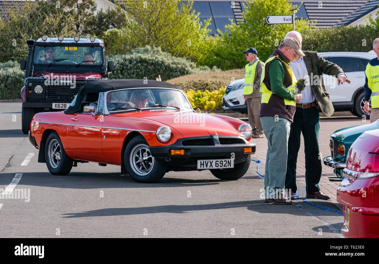 East Lothian, UK. 28 avril 2019. Voiture Classique Tour : North Berwick Rotary Club organise son 3ème rallye avec 65 voitures inscrites. La voiture parcours est de East Lothian et retourner par le Scottish Borders, la collecte de fonds pour les organismes de bienfaisance locaux. Les voitures se réunissent à North Berwick avant de démarrer. Une orange 1974 MG voiture sport décapotable Banque D'Images