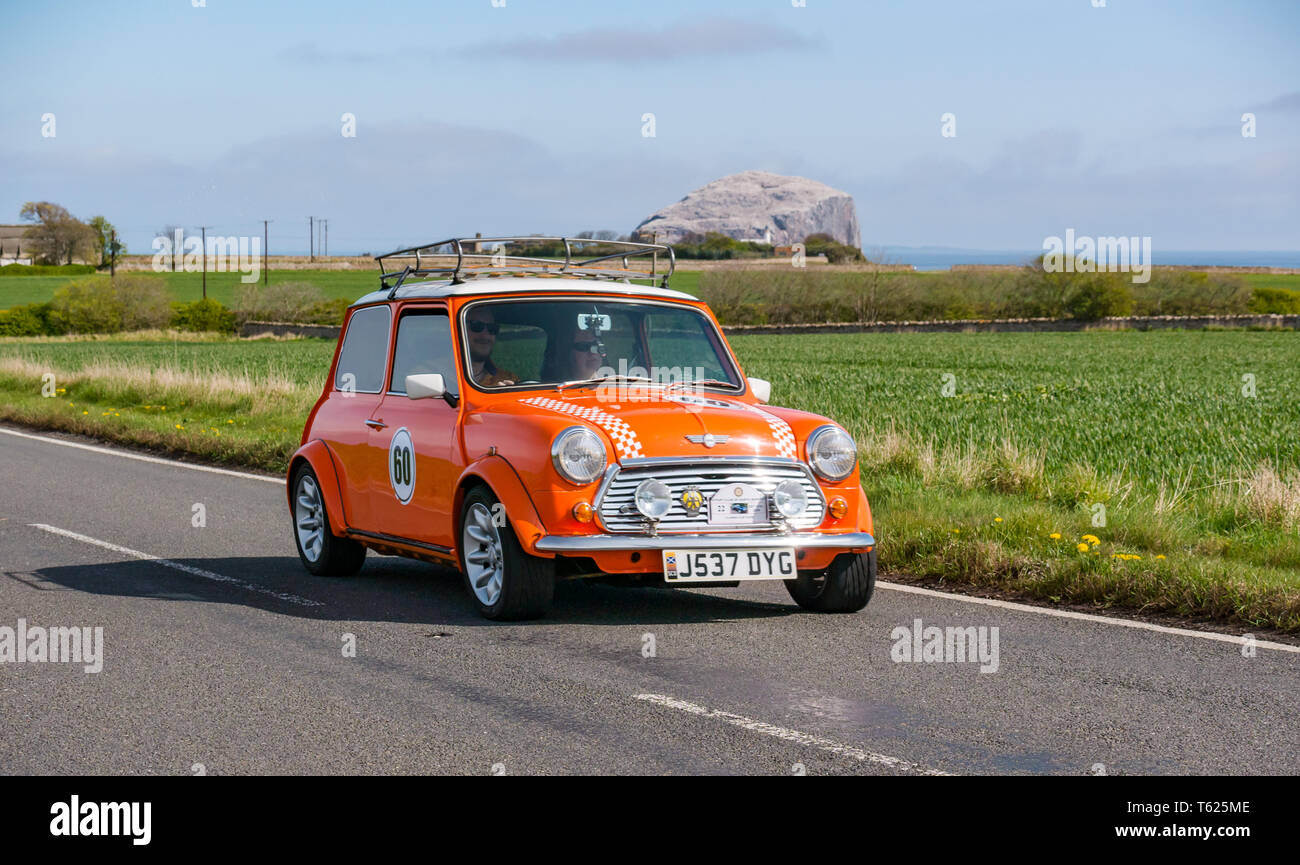 East Lothian, UK. 28 avril 2019. Voiture Classique Tour : North Berwick Rotary Club organise son 3ème rallye avec 65 voitures inscrites. La voiture parcours est de East Lothian et retourner par le Scottish Borders, la collecte de fonds pour les organismes de bienfaisance locaux. Un orange vintage 1991 Rover Mini Cooper avec Bass Rock dans l'arrière-plan Banque D'Images