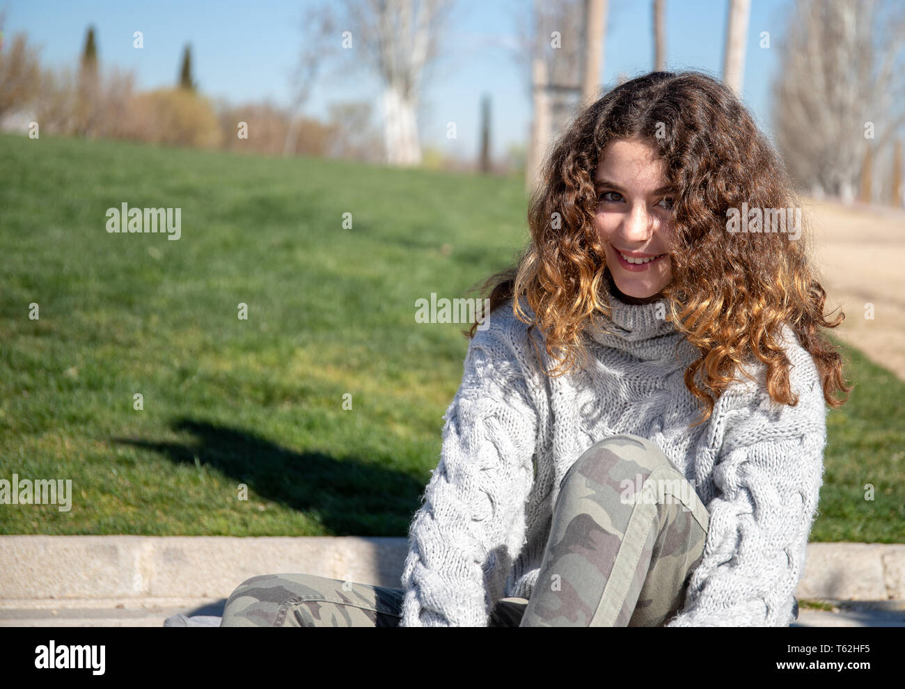 Portrait d'une pré-adolescente, posant dans un parc public sur un jour de printemps ensoleillé Banque D'Images