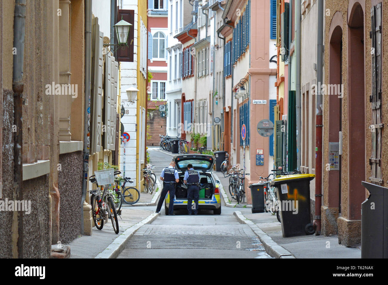 Voiture de police avec deux agents en patrouille dans la petite rue de centre-ville historique de Heidelberg en Allemagne Banque D'Images