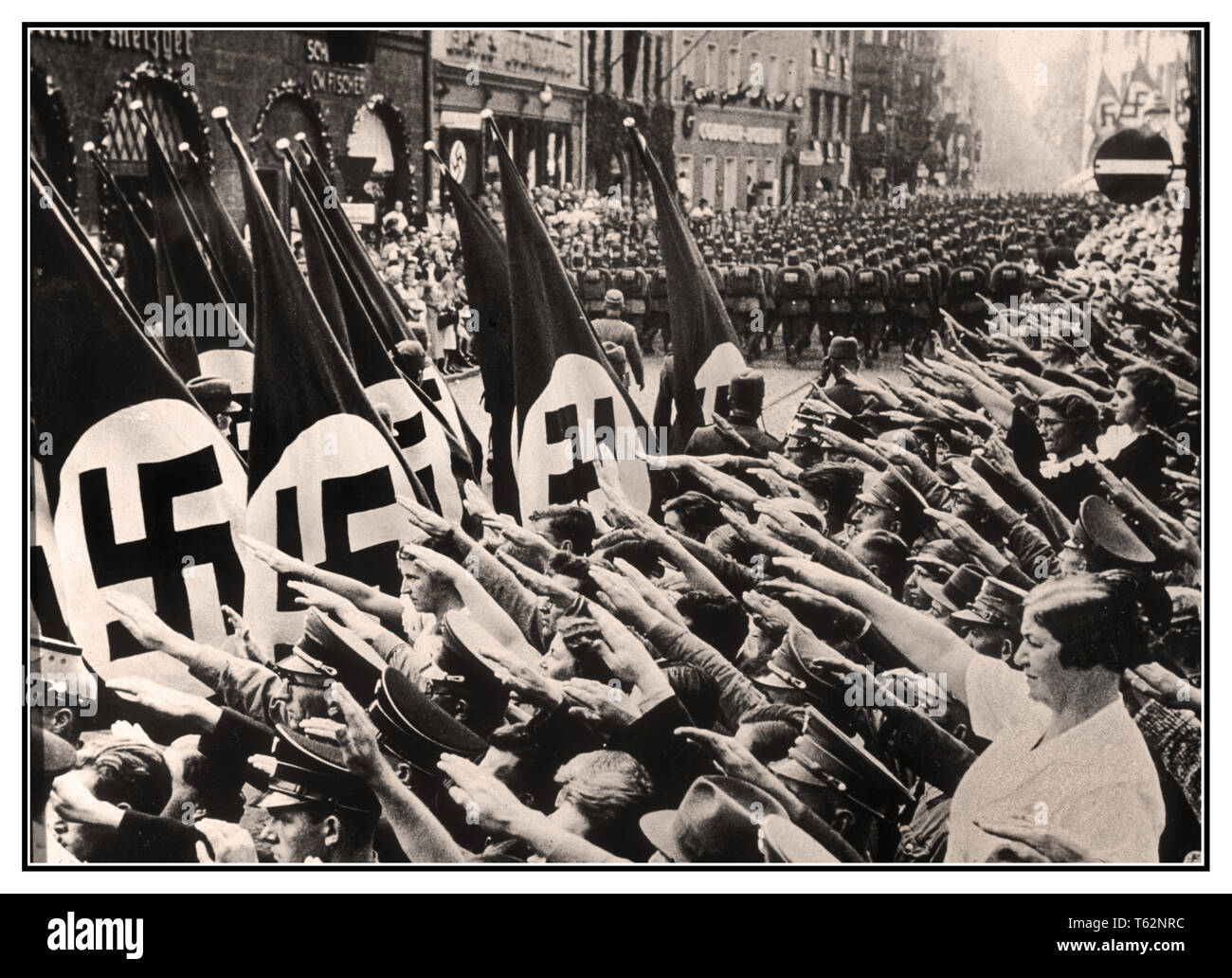 HEIL HITLER NUREMBERG drapeaux à croix gammée salue la foule dans la rue de Nuremberg Allemagne nazie, Heil Hitler salute Nazi comme Corps du travail passé mars portant des drapeaux à croix gammée. Célébration du défilé Parti national socialiste et réunion à Nuremberg, Allemagne 1937 Banque D'Images