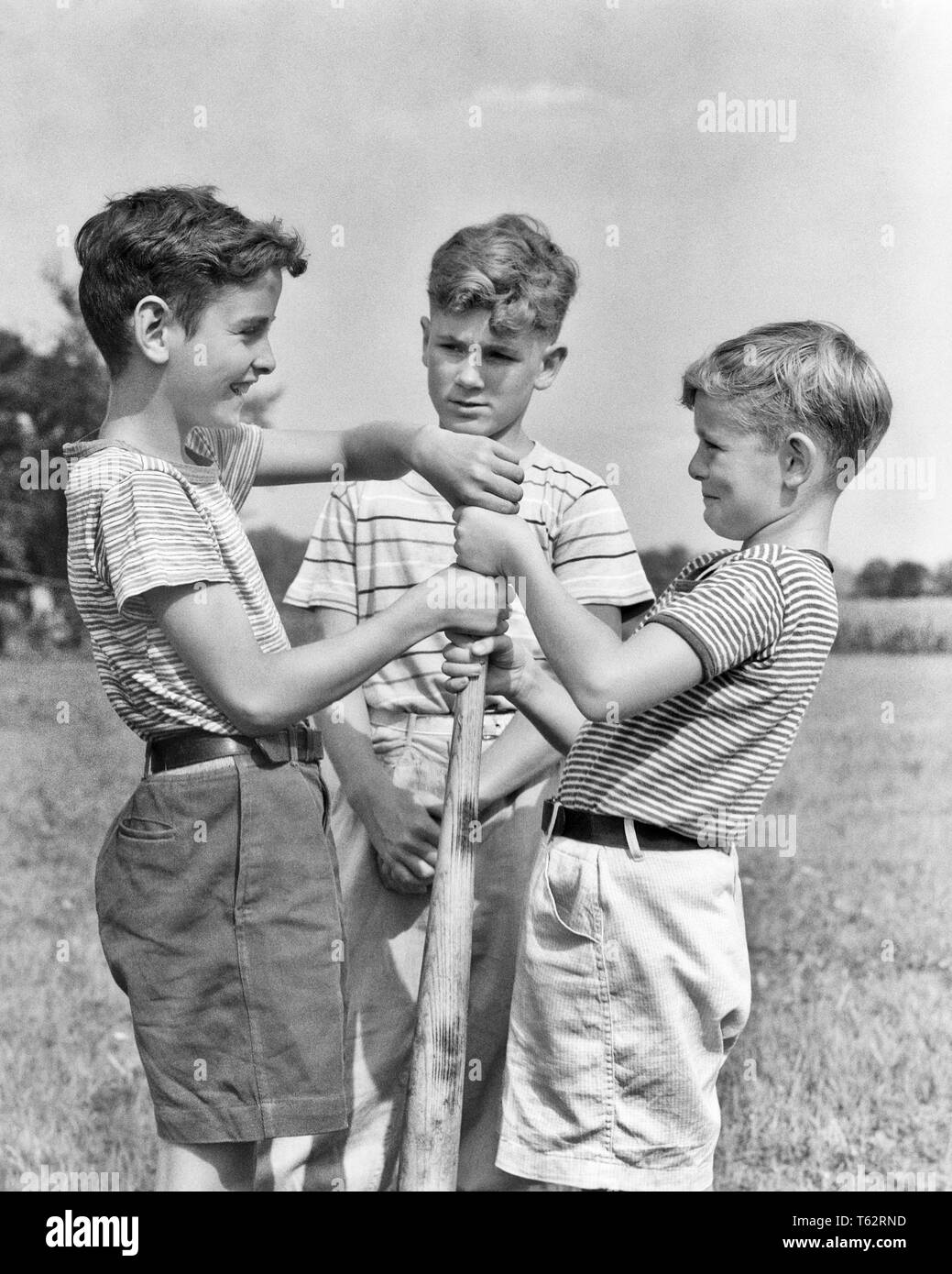 Années 1930 Années 1940 GARÇONS AYANT MAIN SUR MAIN SUR BATTE DE BASE POUR LE CHOIX D'autre main haute gagne - b4834 HAR001 MÂLES HARS AMERICANA B&W L'ÉTÉ DANS LA RÉGION DE LOISIRS SANDLOT tee shirts connexion T-SHIRTS REMPORTE LE MATCH DE SPORT À LA CROISSANCE DES juvéniles de coopération pré-ADO PRE-TEEN BOY CÔTÉS batte de base NOIR ET BLANC DE L'ORIGINE ETHNIQUE CAUCASIENNE CHOISIR HAR001 old fashioned Banque D'Images