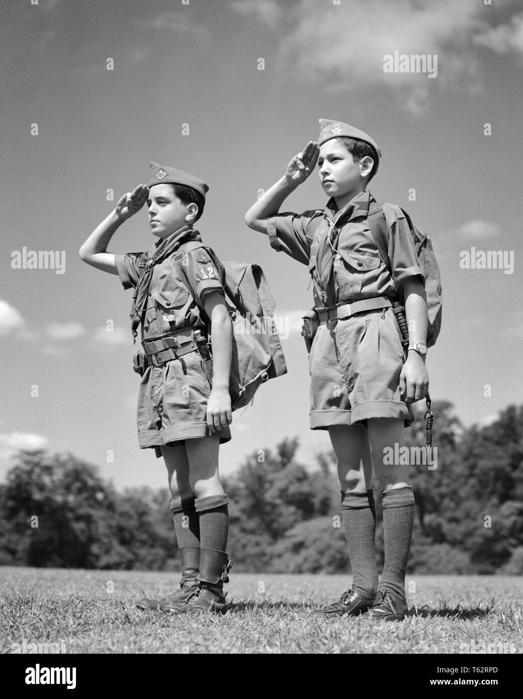 Années 1950 DEUX SCOUTS portant des uniformes d'ÉTÉ AU GARDE ÉQUIPÉ DE SACS À MAIN à trois doigts saluant - b6033 HAR001 HARS DE SANTÉ DE LA VIE DE L'AMITIÉ DE PRENDRE SOIN DES FRÈRES ET SŒURS SCOUTS MÂLES SPIRITUALITÉ CONFIANCE B&W BONHEUR AVENTURE JOYEUSE SALUE LE COURAGE FORCE ATTENTION CHOIX LOISIRS LEADERSHIP FIERTÉ DE L'uniforme d'enfant de boy-scout CONNECTION THRIFTY CHAUSSETTES serviable et amical COURTOIS CONCEPTUEL GENRE ÉLÉGANT RESPECTUEUSE DES BOY SCOUTS dignes de sacs à dos sac à dos juvéniles de croissance pré-adolescents fidèles pré-ADO GARÇON SAC À DOS SALUT BRAVE NOIR ET BLANC Banque D'Images
