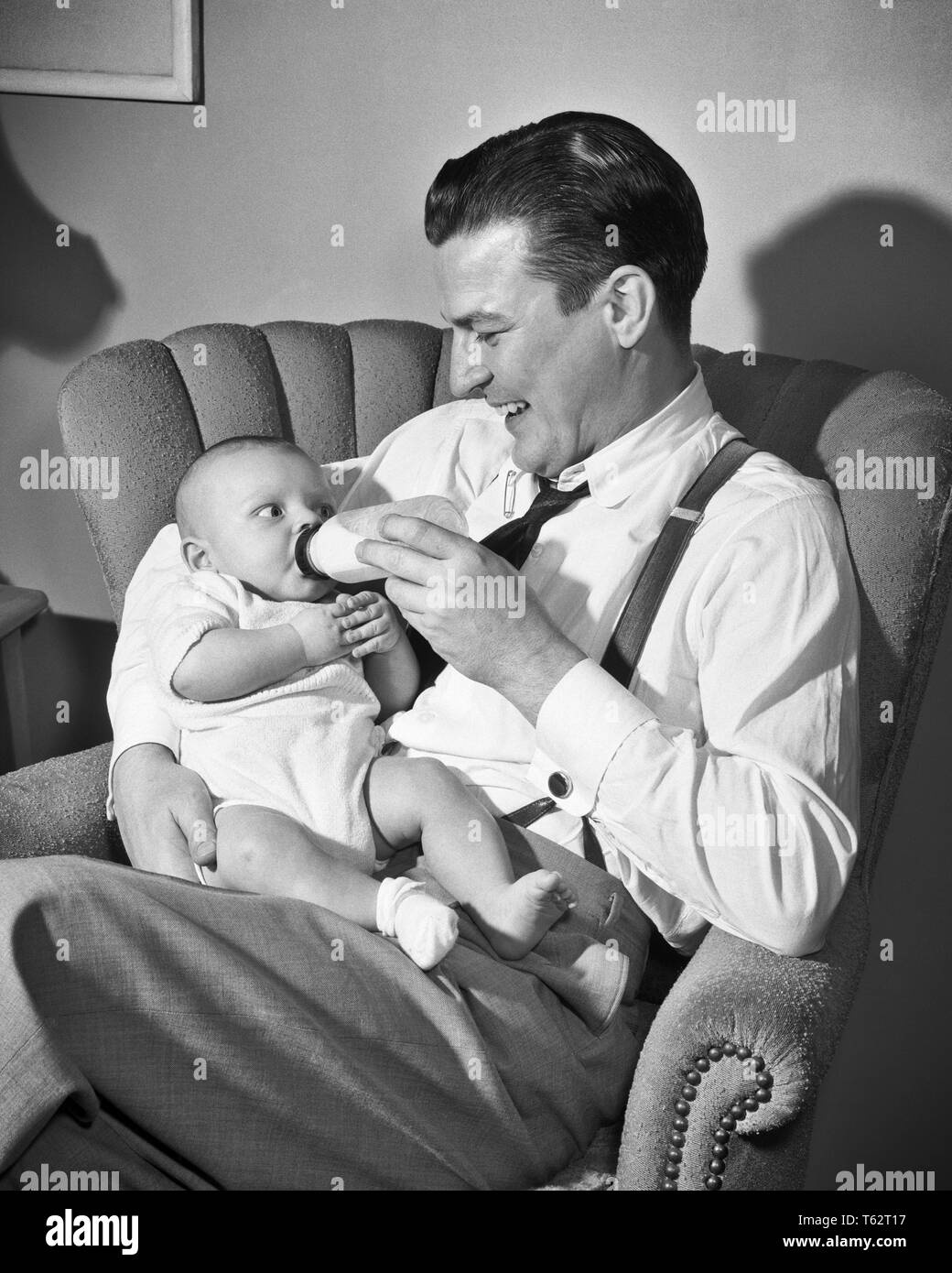 Années 1940 Années 1950 MAN SMILING PÈRE ASSIS DANS LE SALON PRÉSIDENT  HOLDING ET DE LAIT BIBERON BABY BOY FILS - b810 DEB001 HARS VIEUX TEMPS  NOSTALGIE HUGGING ANCIENNE MODE D'ALIMENTATION 1
