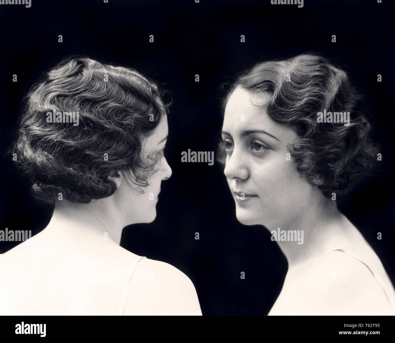 1920 VUES AVANT ET ARRIÈRE DE MÊME BRUNETTE WOMAN DÉMONTRANT MARCEL VAGUE COIFFURE - c5397 HAR001 HARS, CHERS FRÈRES ET SŒURS SŒURS MATCH PERSONNES B&W BRUNETTE CORRESPONDANT À MÊME LA TÊTE ET LES ÉPAULES ET LE CHOIX DES STYLES DE COIFFURE ID COMPOSITE CONFRONTATION FACE À FACE D'ENFANT DE SANTÉ MENTALE VAGUES DOIGT EXEMPLE CONCEPTUEL ondulée à l'apparence élégante de style IMAGE MIROIR DUPLIQUER FASHIONS COIFFURE SE RESSEMBLENT MARCEL YOUNG ADULT MAN WOMAN NOIR ET BLANC DE L'ORIGINE ETHNIQUE CAUCASIENNE HAR001 CLONE démontrant l'ANCIENNE IDENTITÉ D'UNE MALADIE MENTALE Banque D'Images