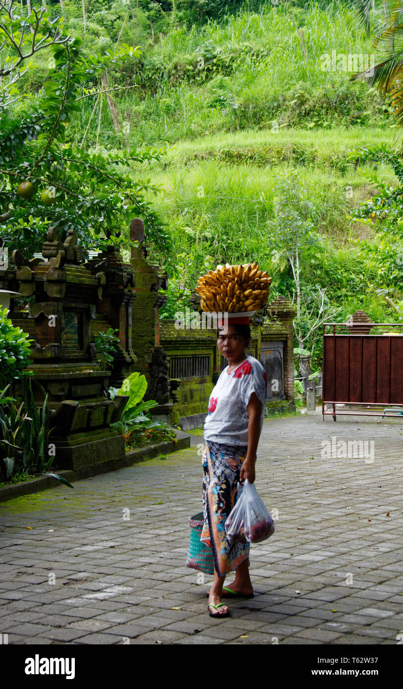 Femme indonésienne transportant des colis de bananes sur la tête, Ubud, Bali, Indonésie Banque D'Images