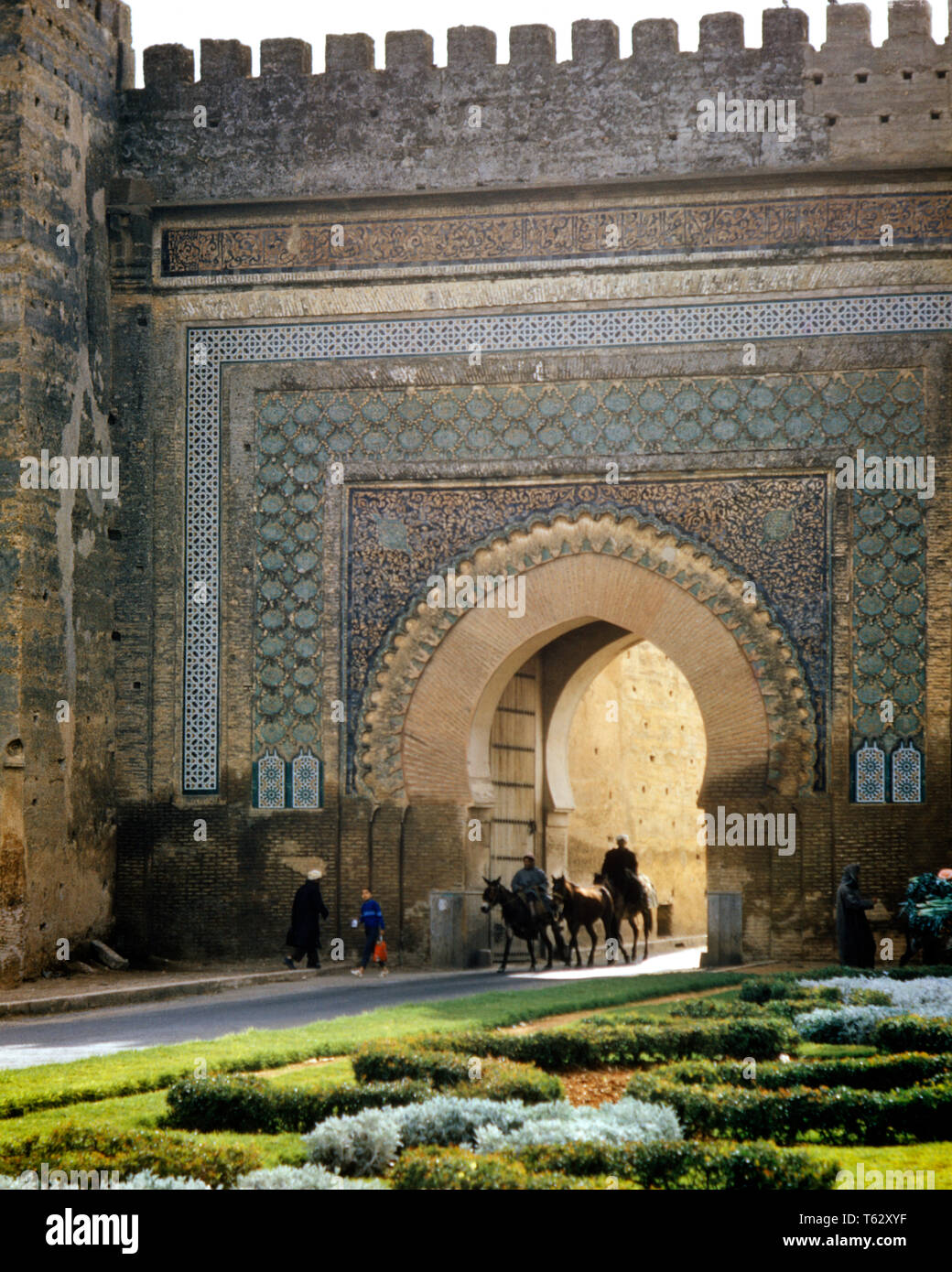 90 Trois personnes anonymes qui se profile et deux ânes passant au travers d'un sol carrelé ET PORTE MAURESQUE CRÉNELÉES À Fès MAROC - KR11738 FIL001 AU HARS 8 Fès céramique carrelage élégant 9 MAURE ÂNES ANONYME ASCENDANCE berbère de passerelle à l'ANCIENNE AFRIQUE DU NORD MAROC Banque D'Images