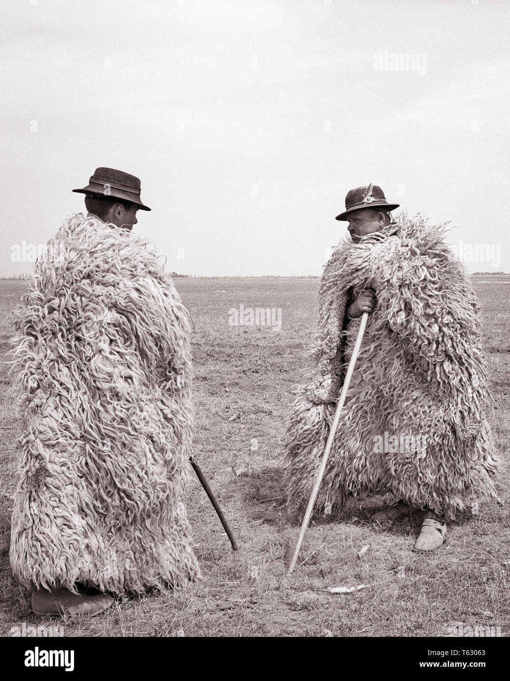 1960 deux bergers HONGROIS PORTANT DES COUCHES DE PROTECTION en peau de mouton de vents glacés de la puszta LA STEPPE PANNONIENNE - r18378 HAR001 MÂLES HARS B&W L'AGRICULTURE OCCUPATION COMPÉTENCES COMPÉTENCES HUMORISTIQUES BIZARRES STYLES PROTECTION PROFESSIONS COMIQUE COMÉDIE BERGERS LAINEUX MOUTON SHAGGY glacée élégante maison HONGRIE VENTS PERSONNEL MODES NOIR ET BLANC DE L'ORIGINE ETHNIQUE CAUCASIENNE HAR001 old fashioned Banque D'Images