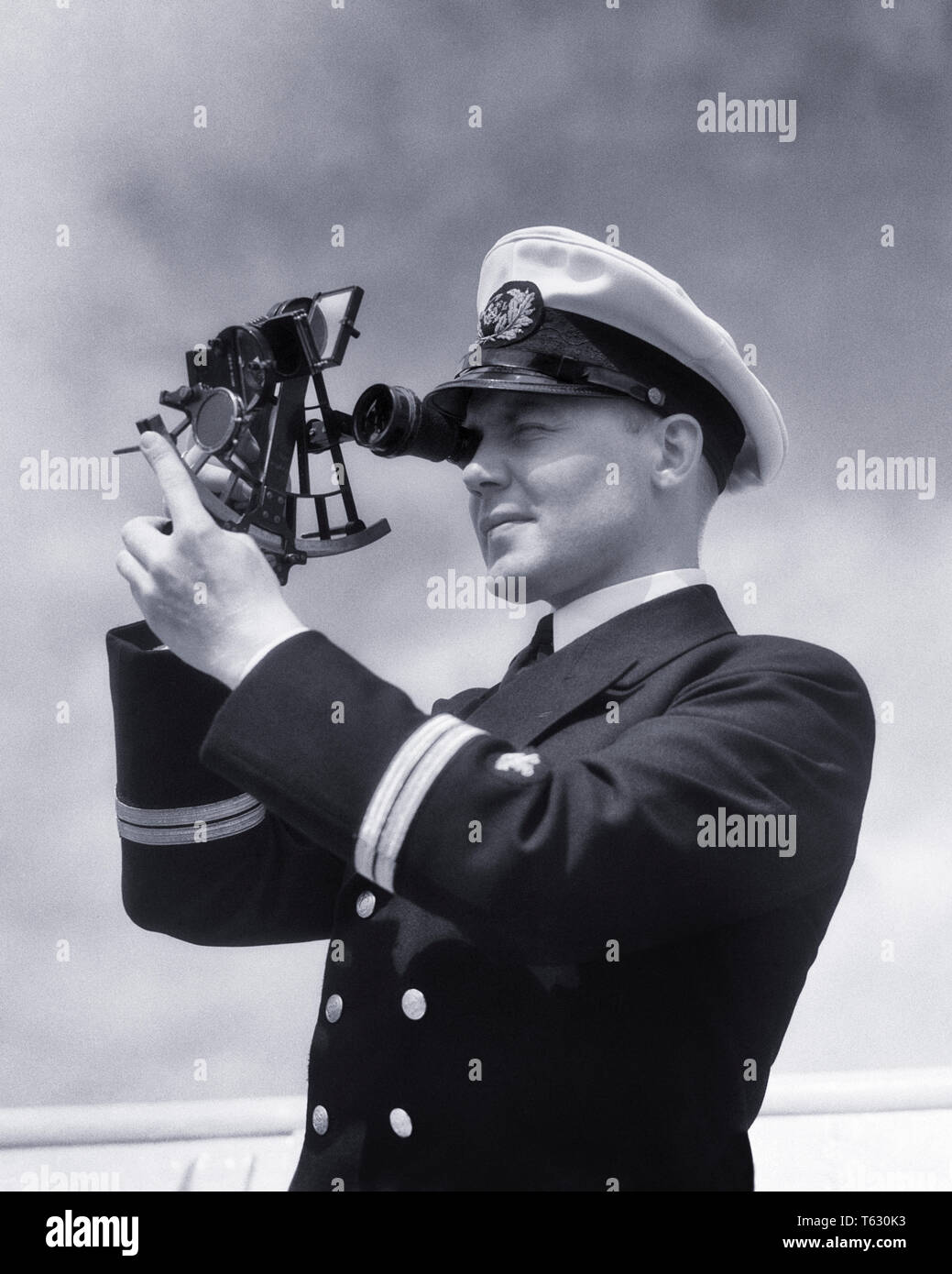 1930 officier de navire à l'aide de sextant pour mesurer les distances angulaires entre les objets de l'outil utilisé à la navigation astronomique - s5654 HAR001 B&W TRANSPORT HARS COMPÉTENCES COMPÉTENCES PROFESSION SEXTANT MARINE AVENTURE NAVIGATION CARRIÈRES PROFESSIONS EN UTILISANT DES OBJETS SENS CONCEPTUEL UTILISÉ CONNEXION CÉLESTE DU NAVIRE D'EXPÉDITION DE PRÉCISION DE NAVIGATION ANGULAIRE YOUNG ADULT MAN NOIR ET BLANC DE L'ORIGINE ETHNIQUE CAUCASIENNE HAR001 old fashioned Banque D'Images