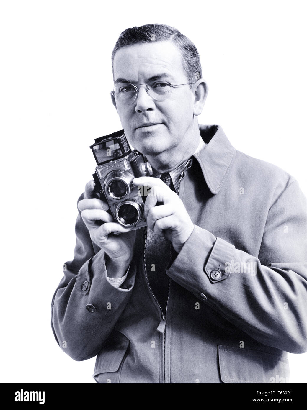 1930 H ARMSTRONG ROBERTS L'ÂGE DE 55 ANS, photographe professionnel à la recherche de l'appareil photo à objectif interchangeable TWIN HOLDING CAMERA FILM EN ROULEAU - u420 HAR001 HARS PERSONNES demi-longueur des mâles de l'INSPIRATION DE LA CONFIANCE DE LA PROFESSION D'ÂGE MOYEN DES EXPRESSIONS B&W middle-aged MAN EYE CONTACT VISION L'OCCUPATION COMPÉTENCES COMPÉTENCES LOISIRS AVENTURE JOYEUSE FIERTÉ LOISIRS CARRIÈRES PROFESSIONS AUTORITÉ PHOTOGRAPHIE CONCEPTUELLE SOURIT H ARMSTRONG ROBERTS ÉLÉGANT JOYEUSE CRÉATIVITÉ FILM ROULEAU REFLEX BI-OBJECTIF DÉTENTE NOIR ET BLANC DE L'ORIGINE ETHNIQUE CAUCASIENNE HAR001 old fashioned Banque D'Images