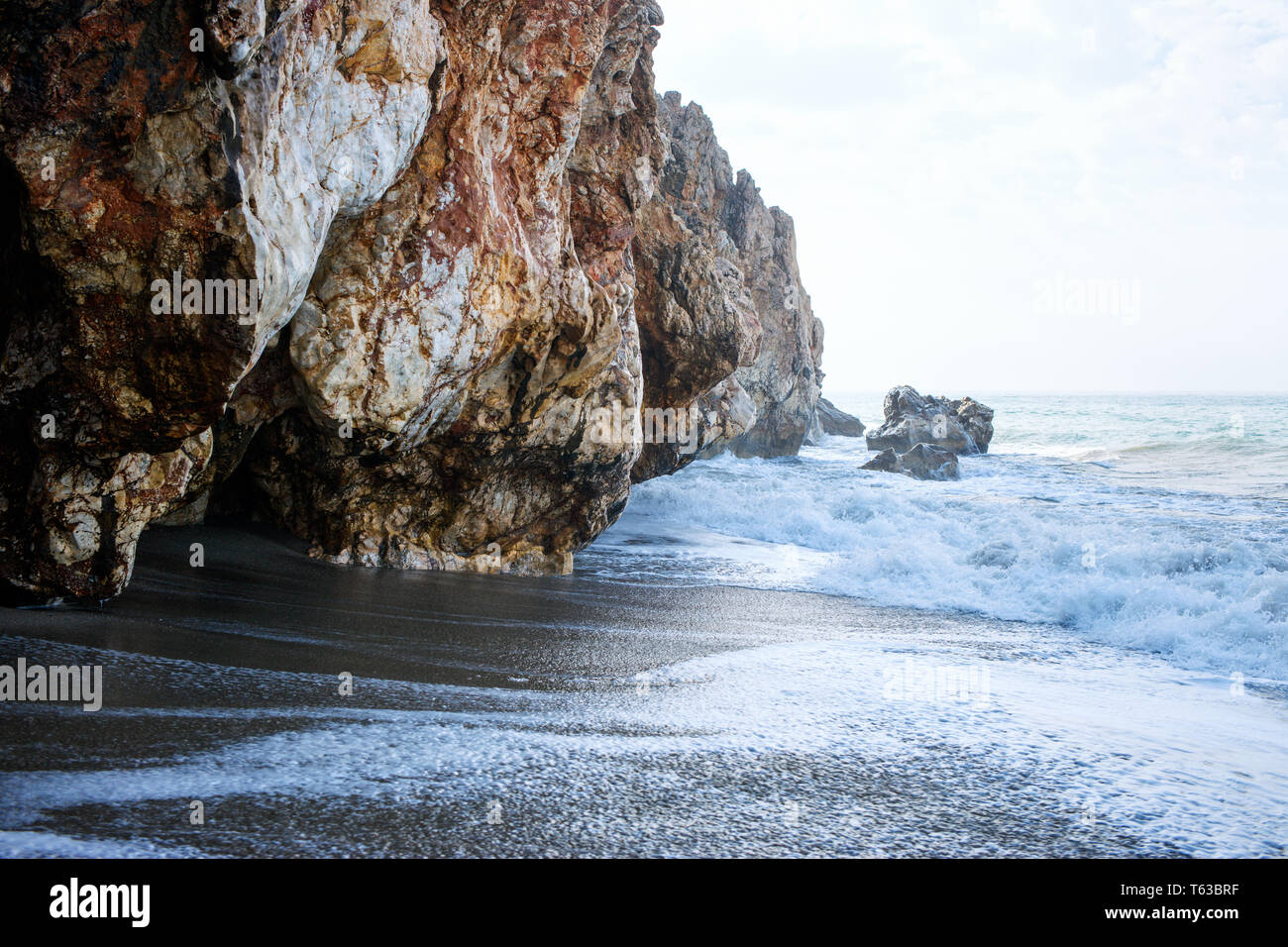Plage de sable fin et des vagues de l'océan bleu avec mousse blanche. Banque D'Images
