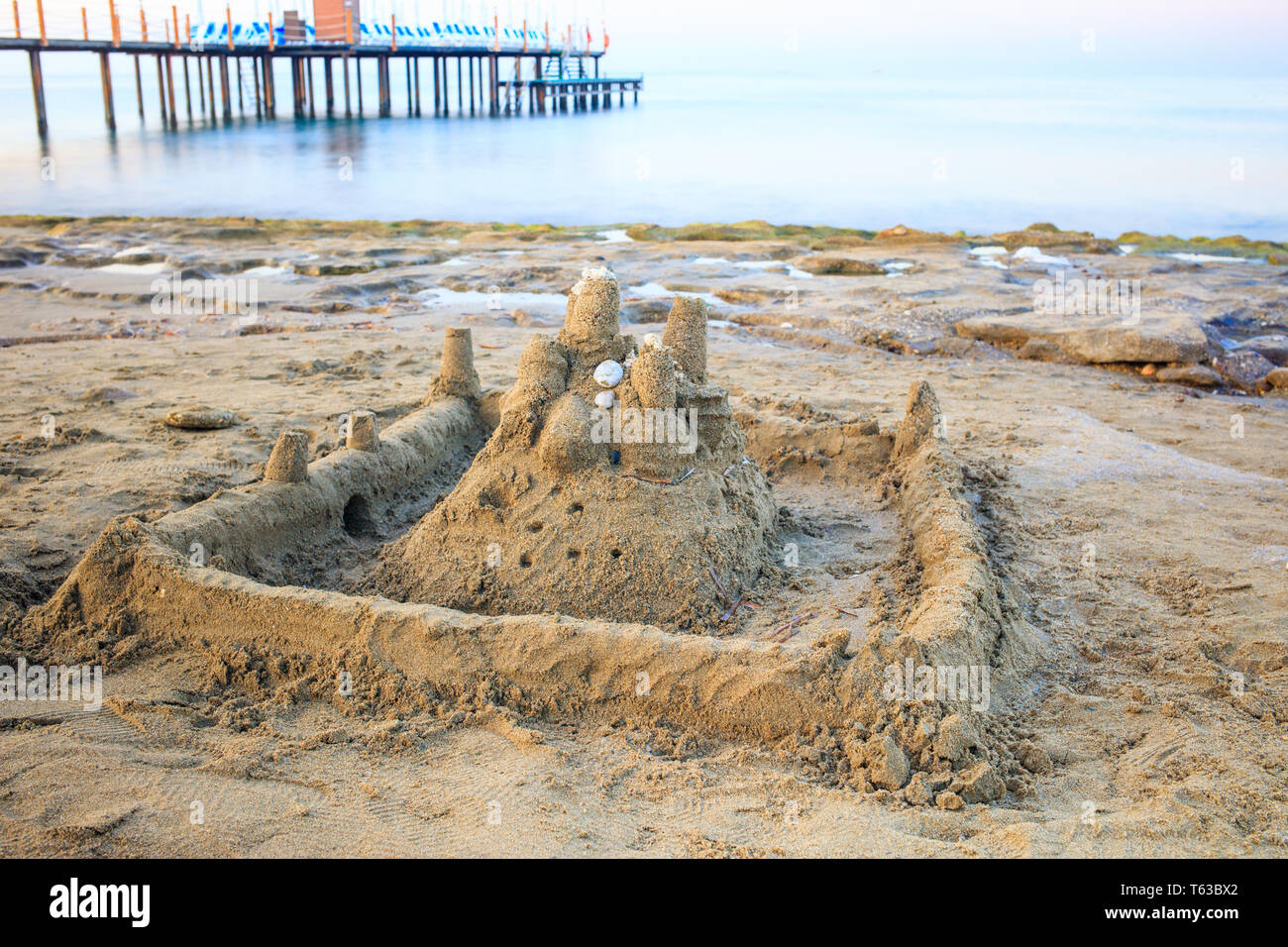 Château de sable sur la plage de sable du matin. Banque D'Images