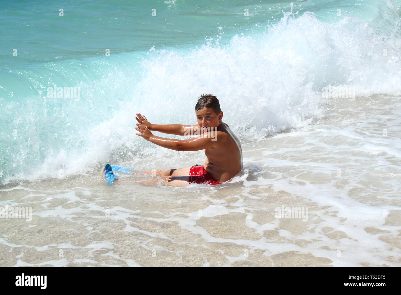 Petit garçon assis et l'arrêt des vagues sur la mer en Croatie Banque D'Images