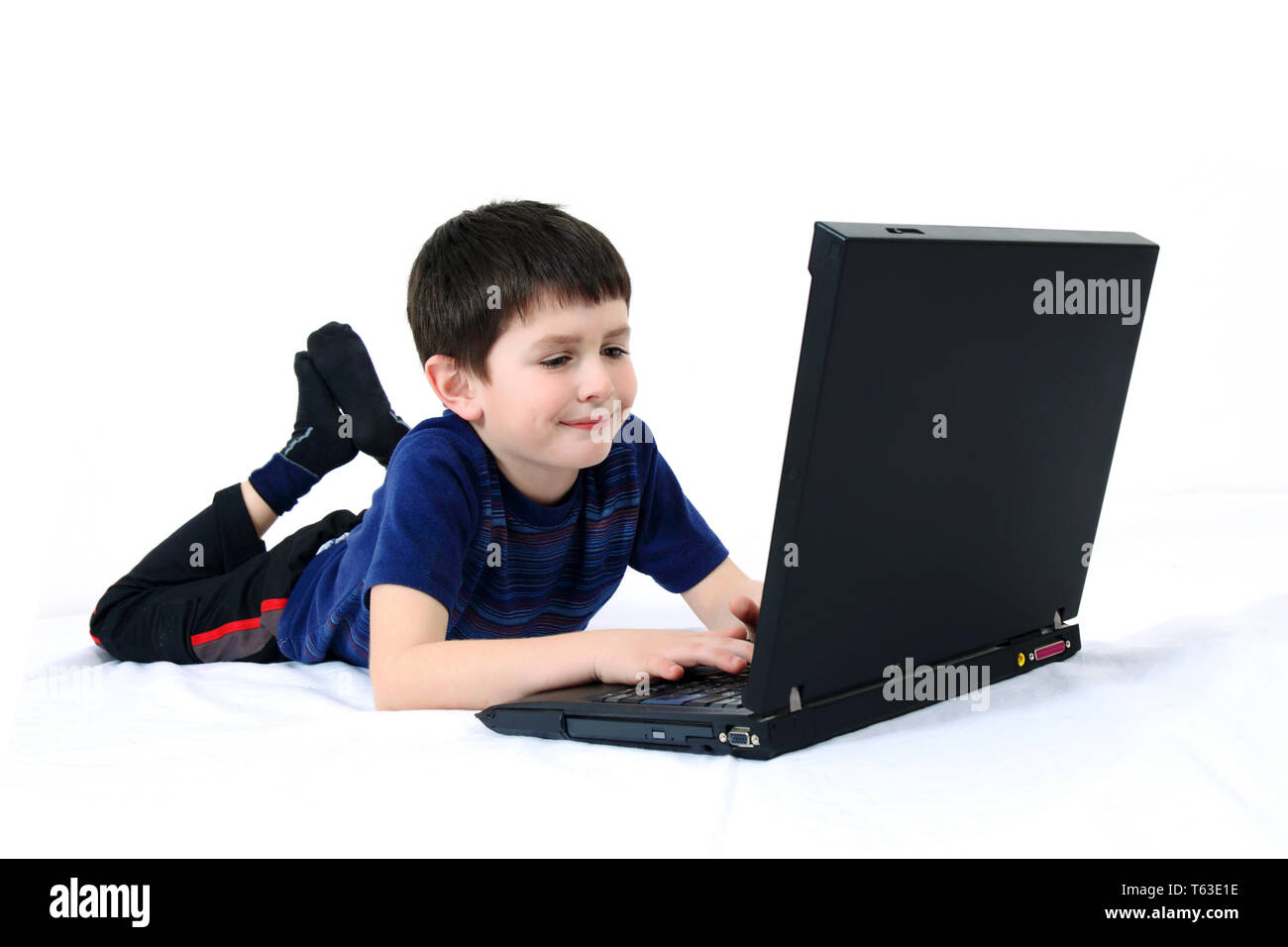 Petit garçon avec un ordinateur portable sur un fond blanc Banque D'Images